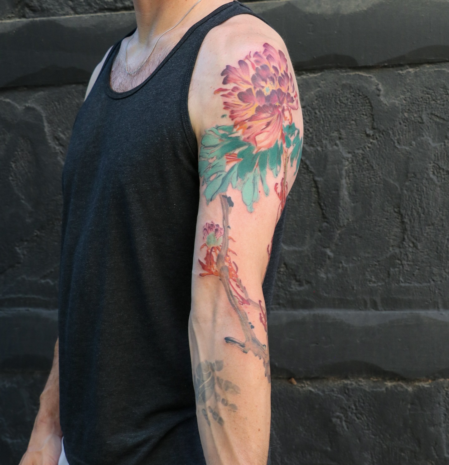 Peony watercolor tattoo on the upper arm by Jhenn