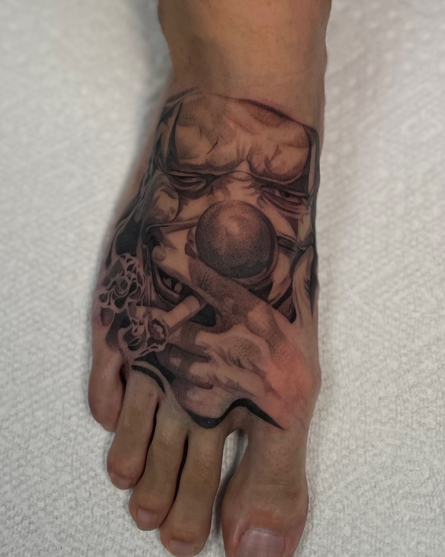 Mask and skull realism tattoo on the foot by Vanessa Valdivia