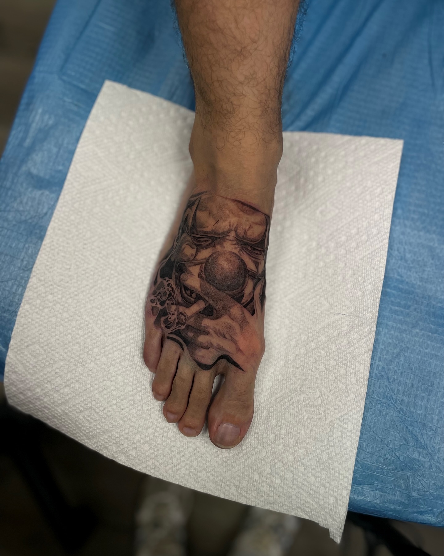 Mask and hands realism tattoo on the foot by Vanessa Valdivia