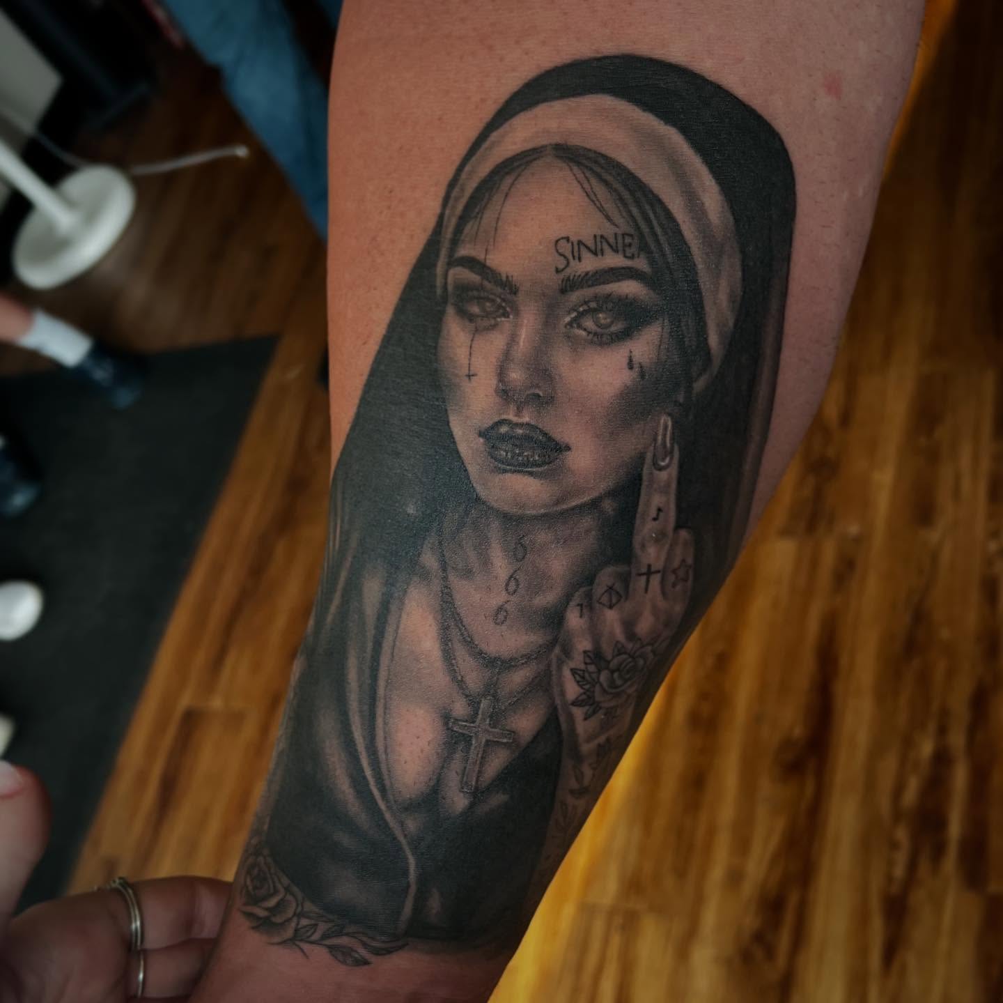Woman with cross dark realism tattoo on the forearm by Taylor Santavicca