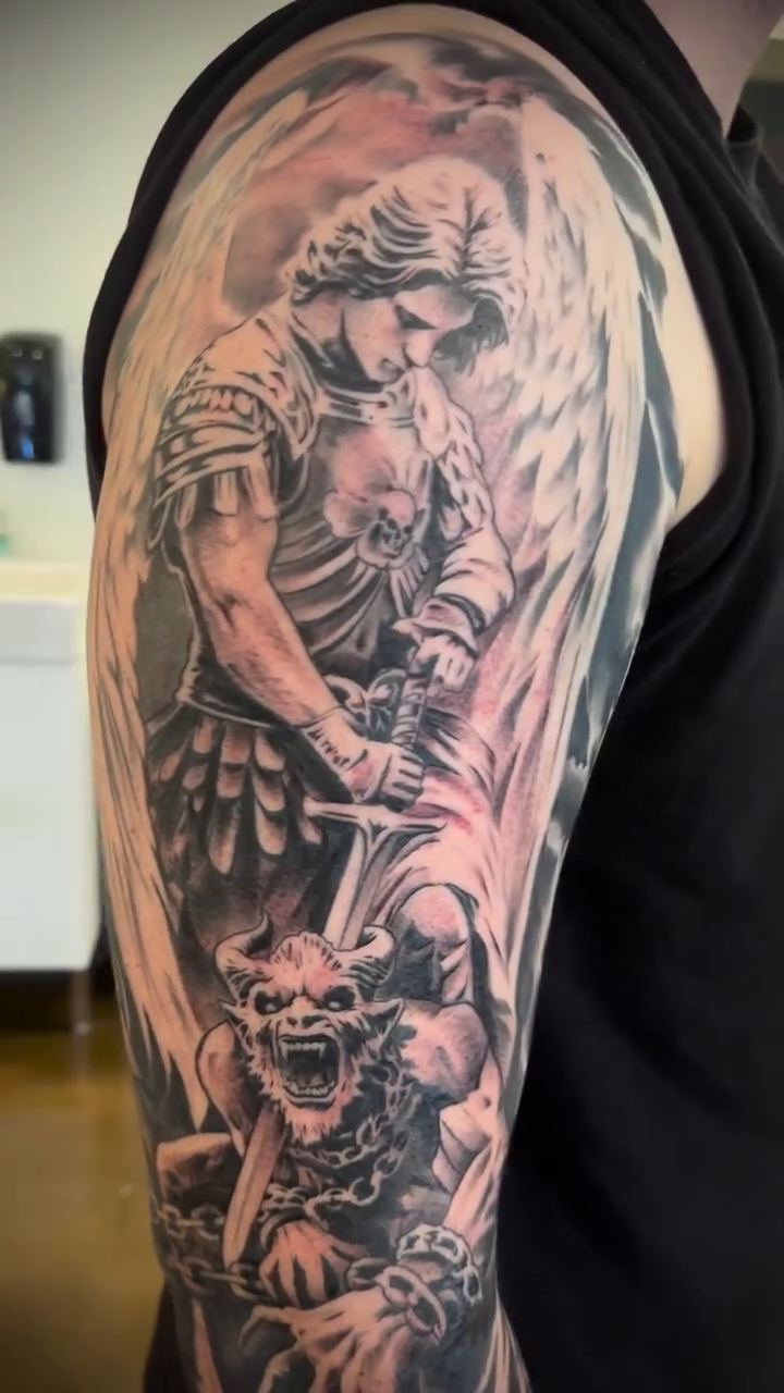 Archangel Michael battling a demon realism tattoo by Mason Williams