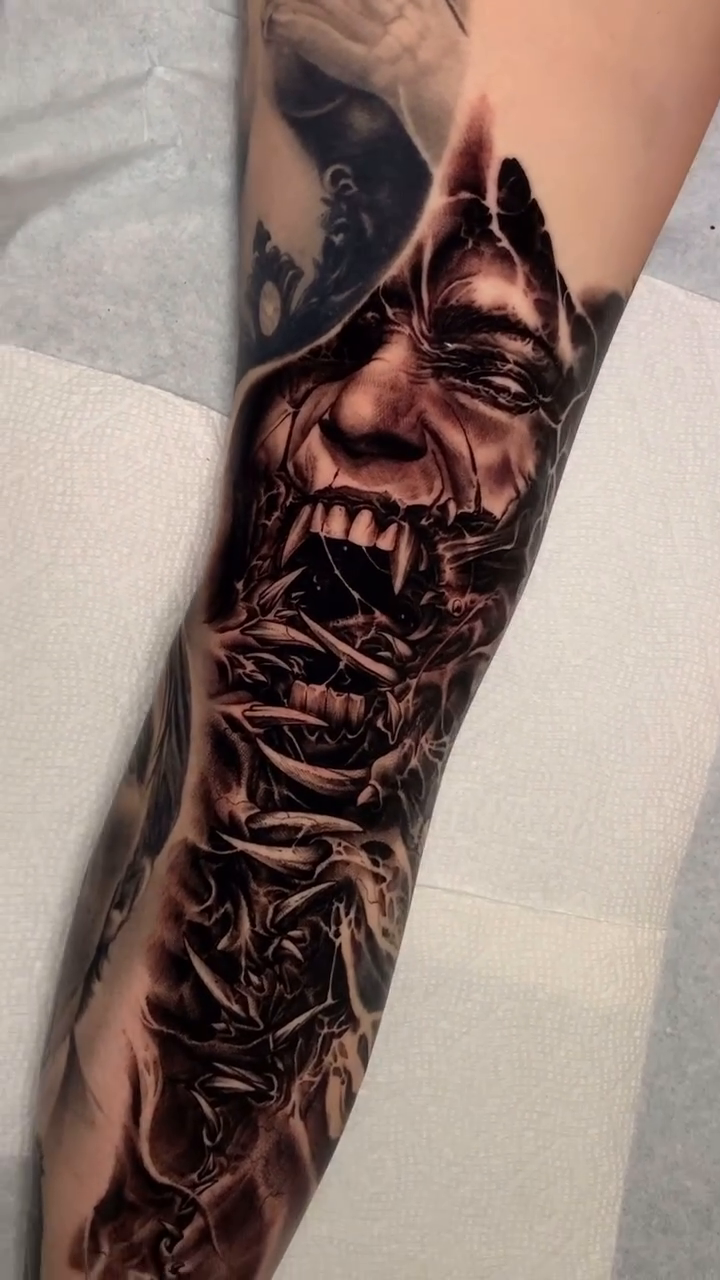 Demonic face with intricate patterns dark realism tattoo by Jake Ross, Mentor, Ohio