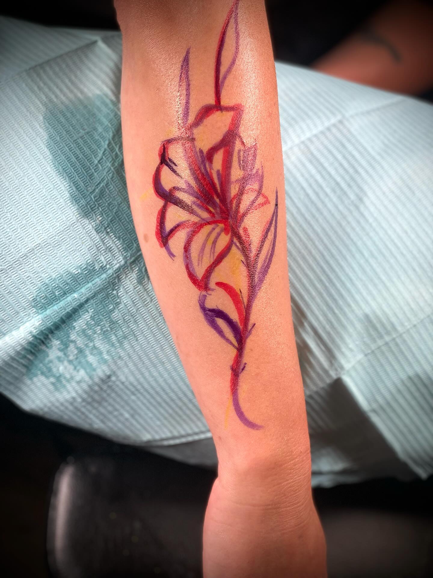 Flower watercolor tattoo on the forearm by Chris Klee