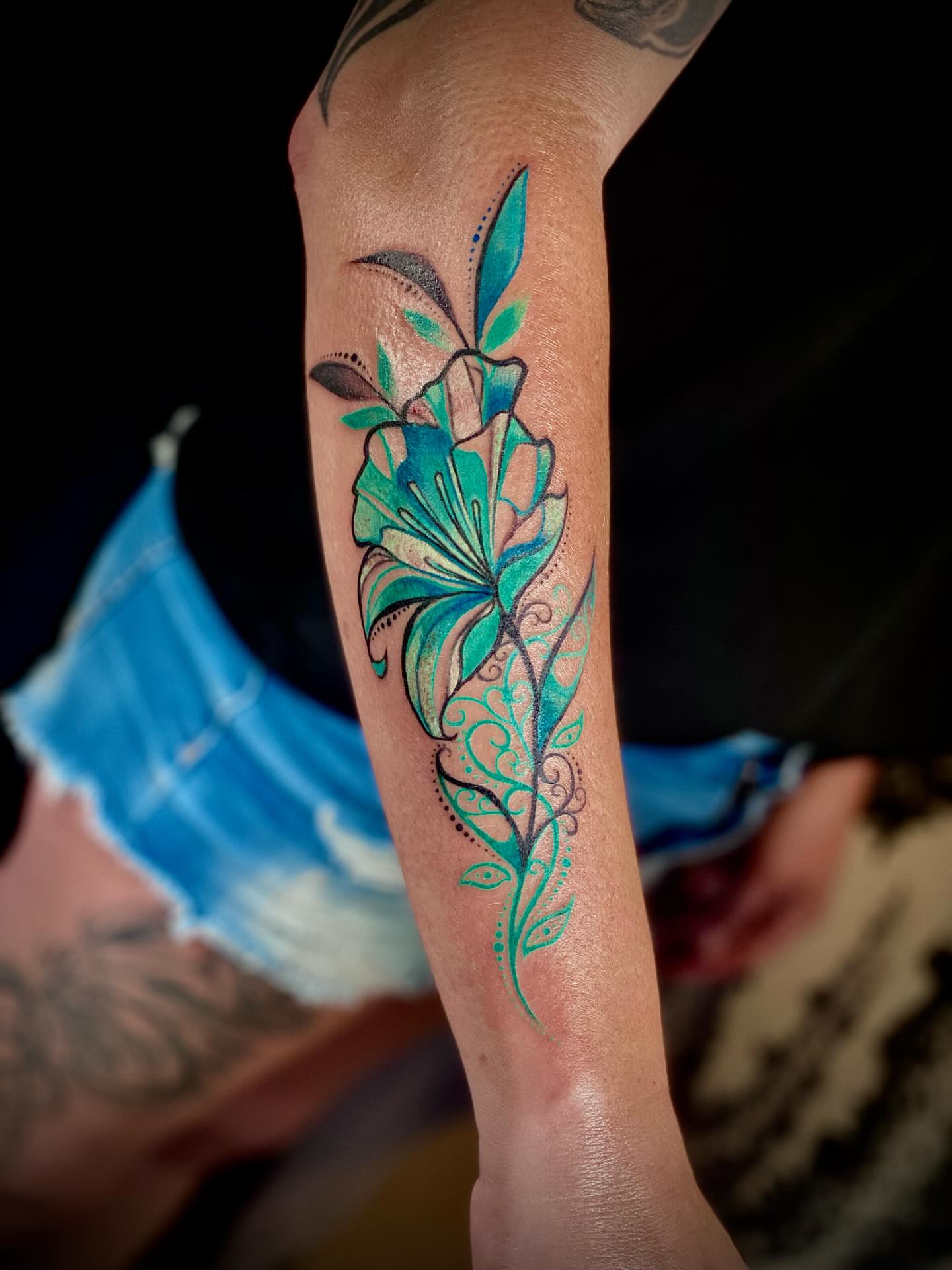 Lily watercolor tattoo on the forearm by Chris Klee