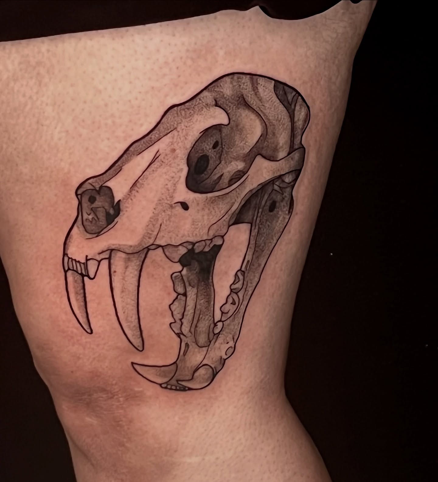 Skull black and grey tattoo on the thigh by Jordan