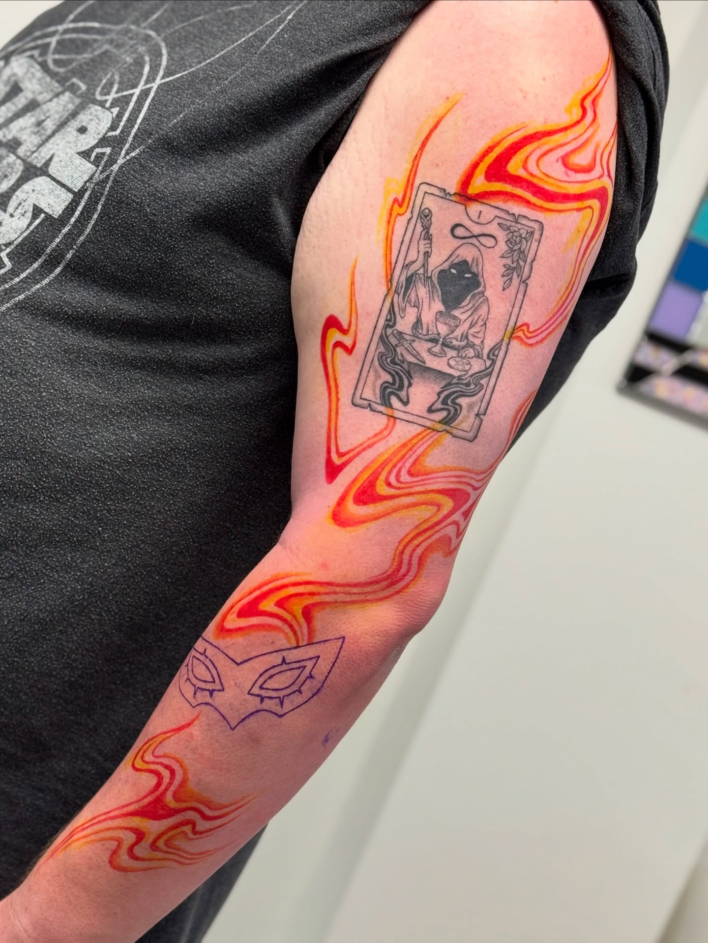 Card with flame neo-traditional tattoo on the forearm by Erin Blaney