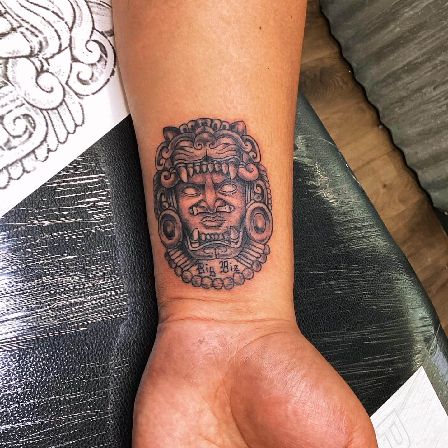 Ancient mask black and grey tattoo on the forearm by Ink by Hailey π