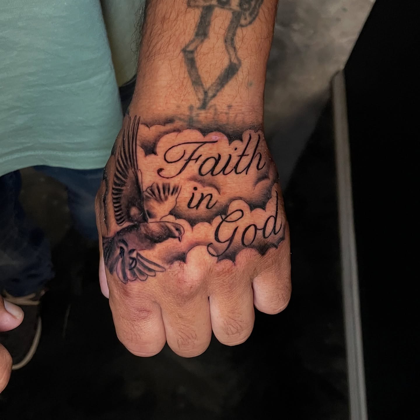 Faith in god black and grey tattoo on the hand by Chubbs