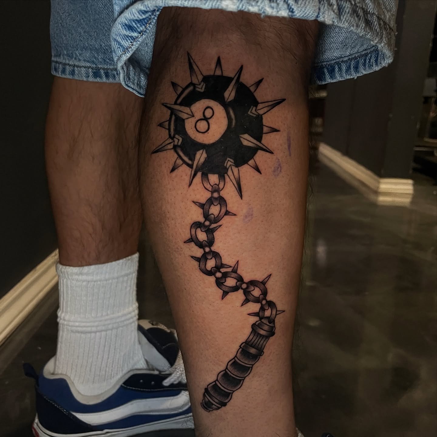 Chain and spiked wheel black and grey tattoo on the thigh by Chubbs