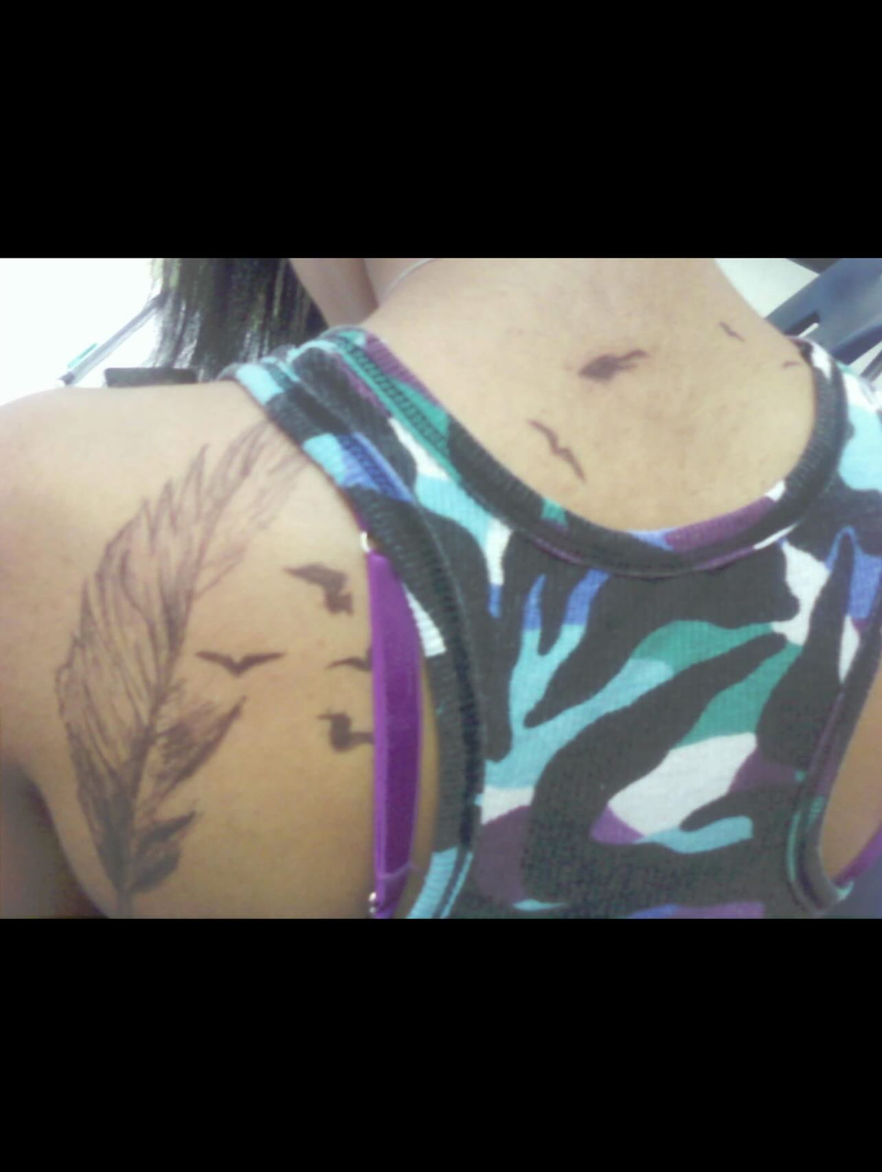 Feather black and grey tattoo on the back by Ashley matthews