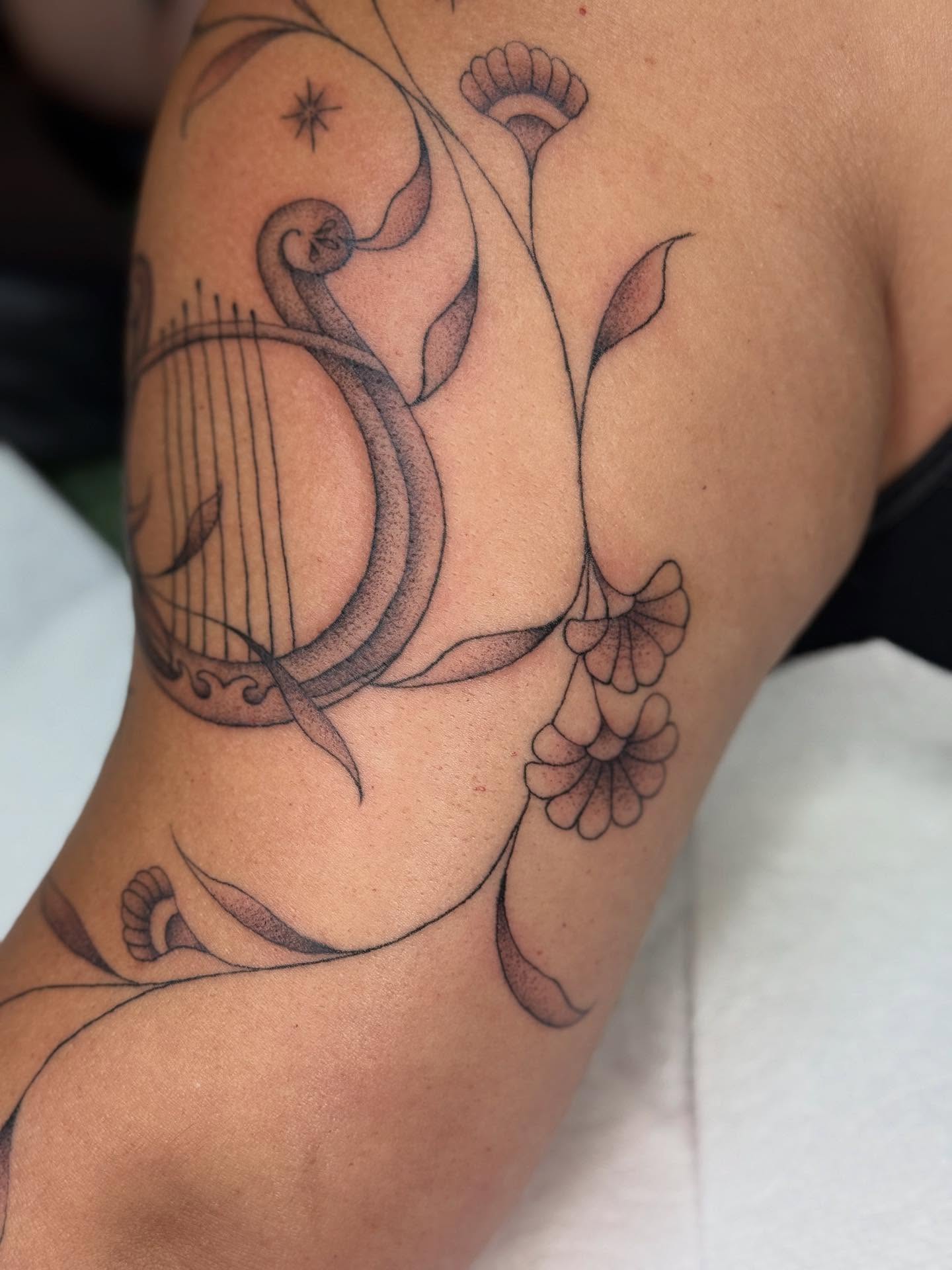 Harp and floral dotwork tattoo on the shoulder by chloe jeanel estrada
