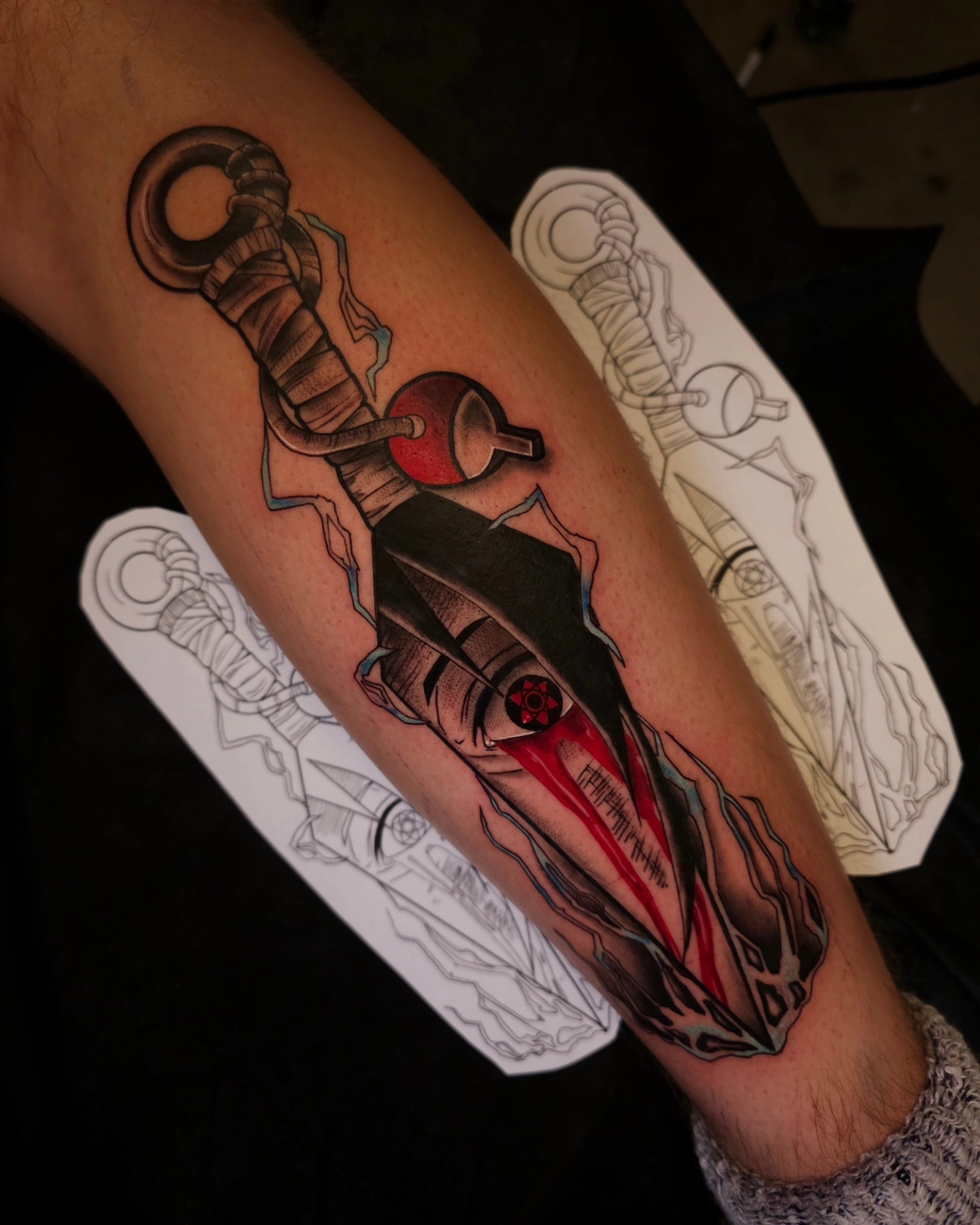 Knife with red blade realism tattoo on the forearm by Devan Vankirk