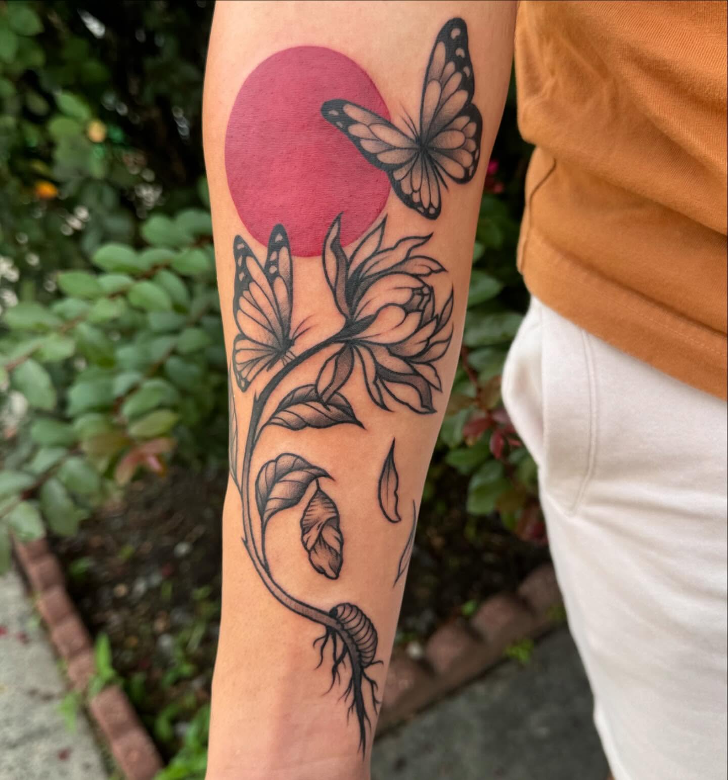 Butterfly and flower black and grey tattoo on the forearm by Makayla Dupre