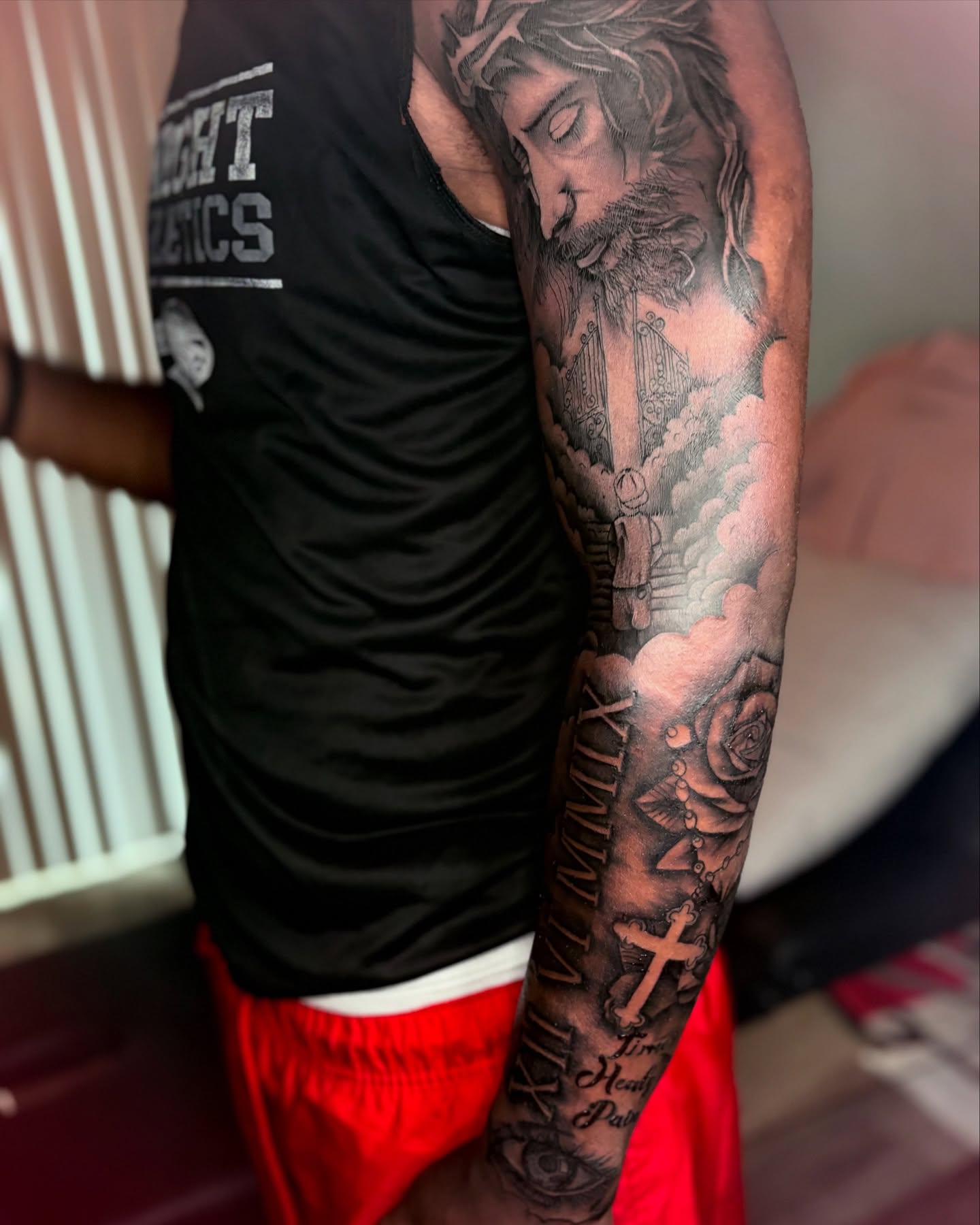 Religious figure realism tattoo on the upper arm by Maleek Inkz