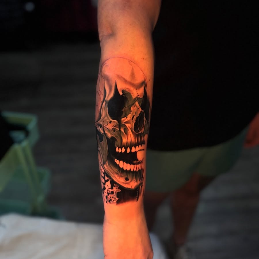 Grinning skull realism tattoo on the forearm by Tay 🥀