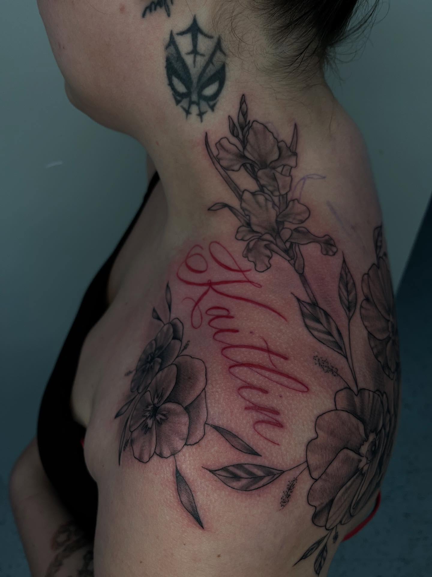 Floral arrangement with name black and grey tattoo on the shoulder by Kenzie Kirk