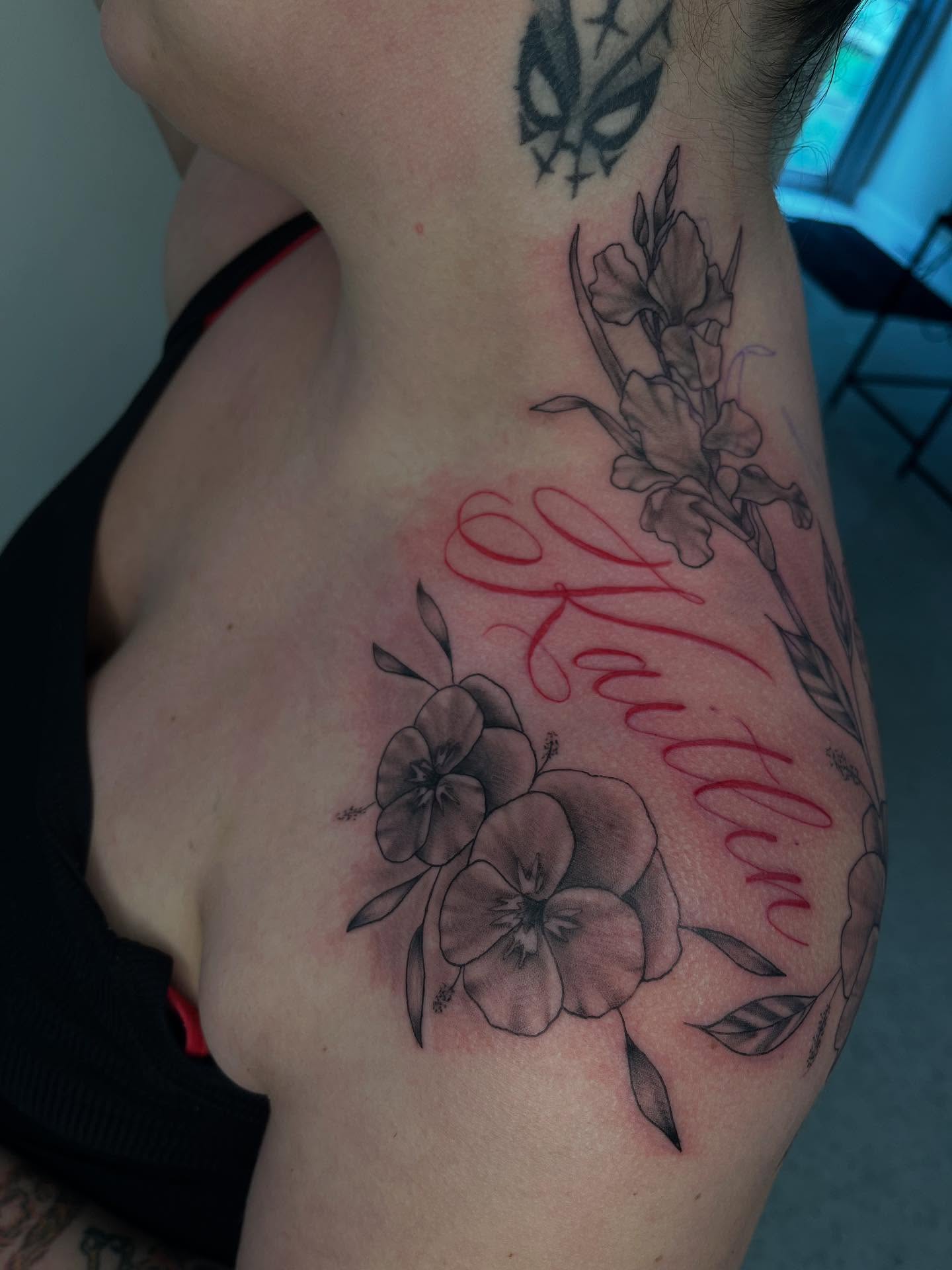 Flowers and name black and grey tattoo on the shoulder by Kenzie Kirk