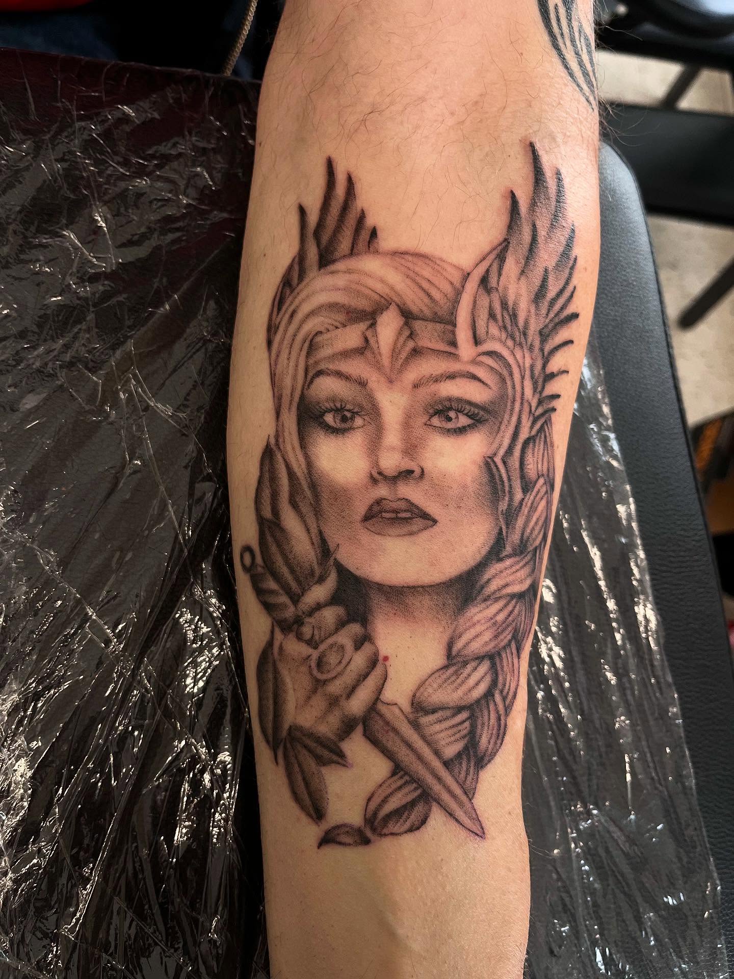Woman with braids realism tattoo on the forearm by Kenzie Kirk