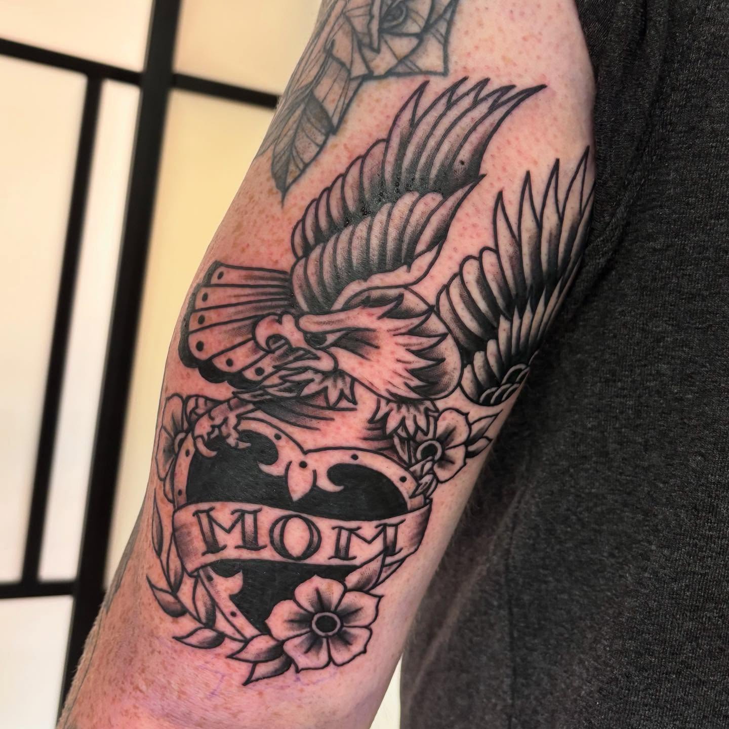 Eagle and floral wreath American traditional tattoo on the forearm by Amy Kolton