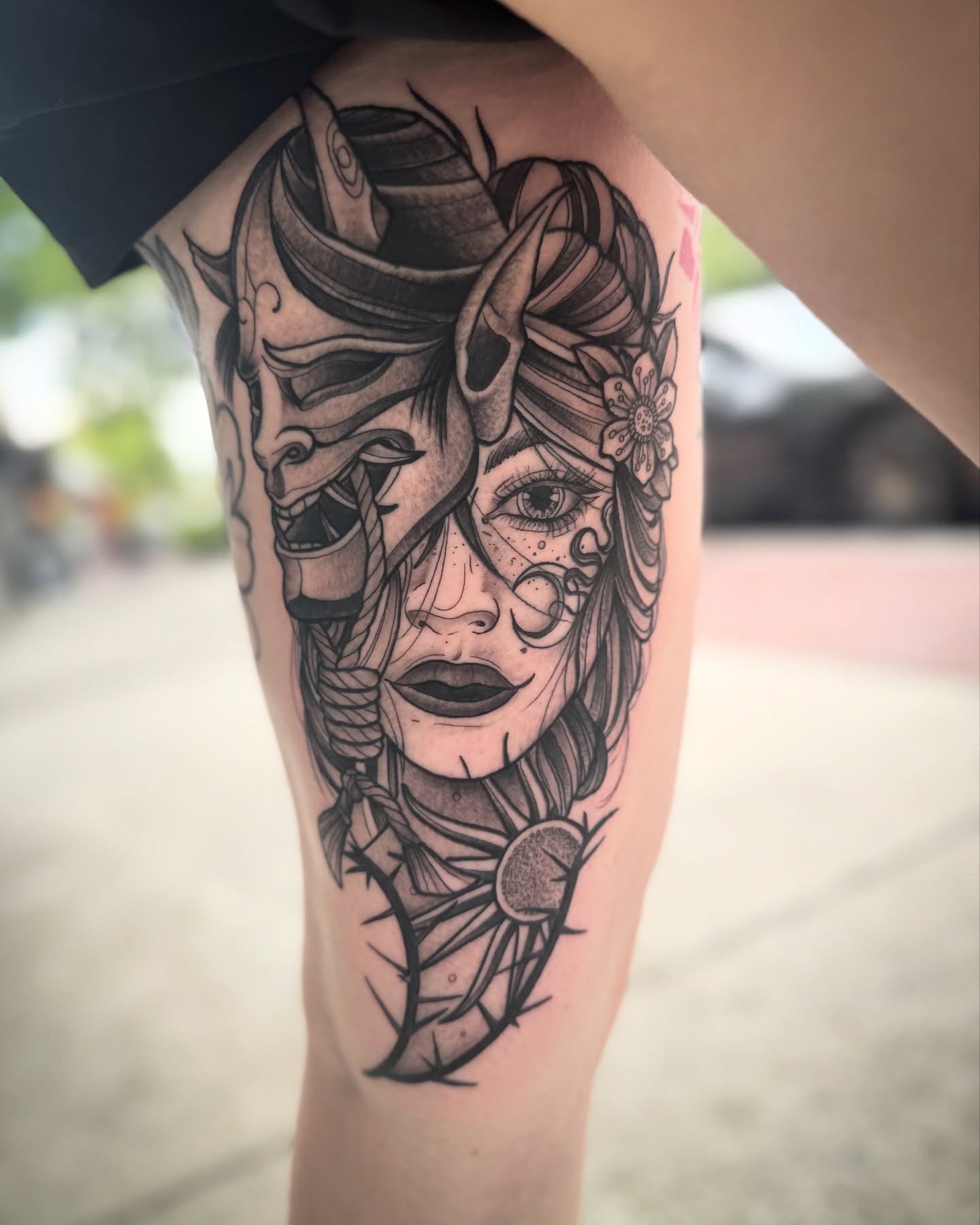 Woman with mask realism tattoo on the thigh by Paul Schnell