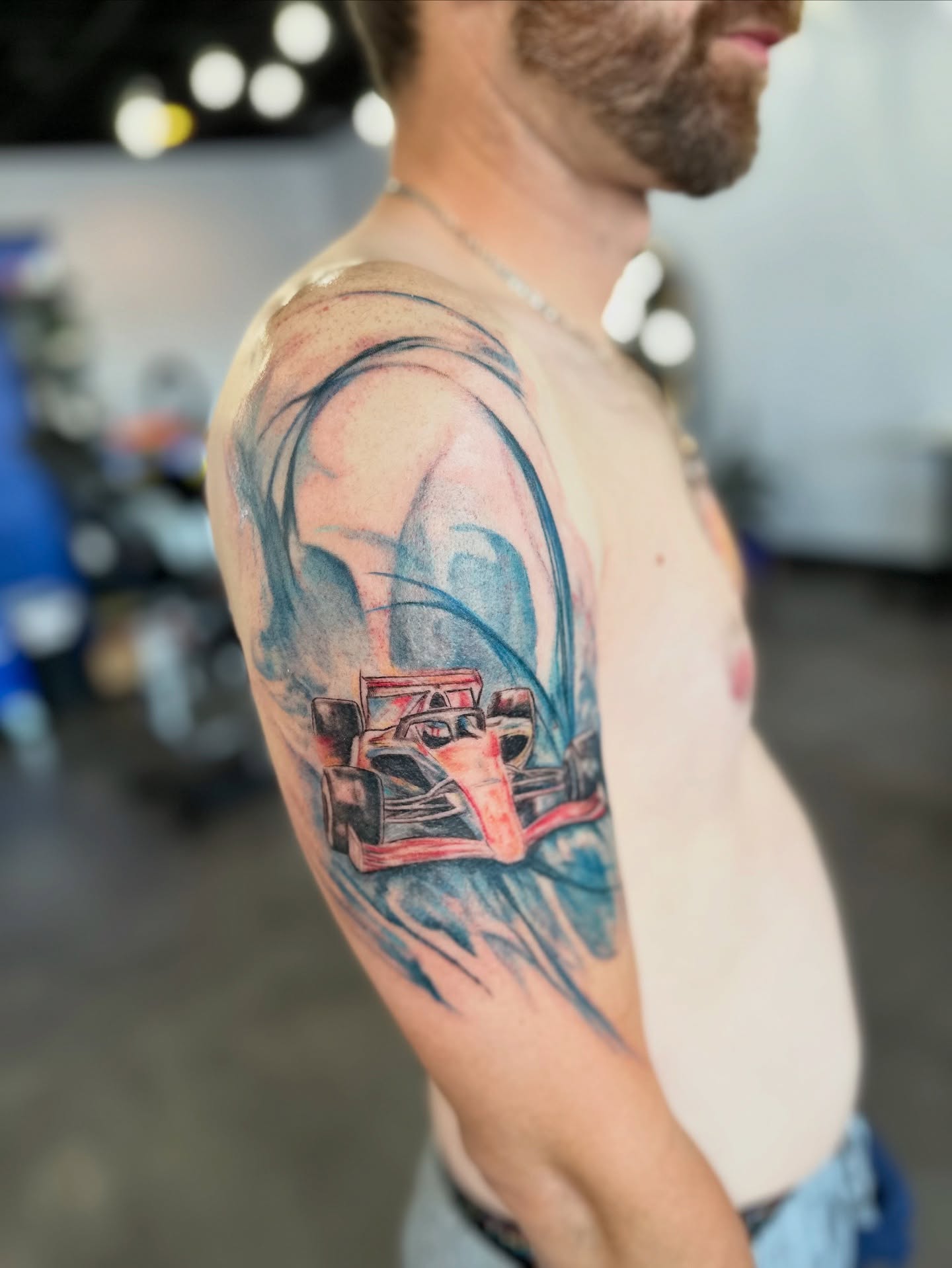 Race car realism tattoo on the upper arm by Cameron Hobbs, Woodbridge, Virginia