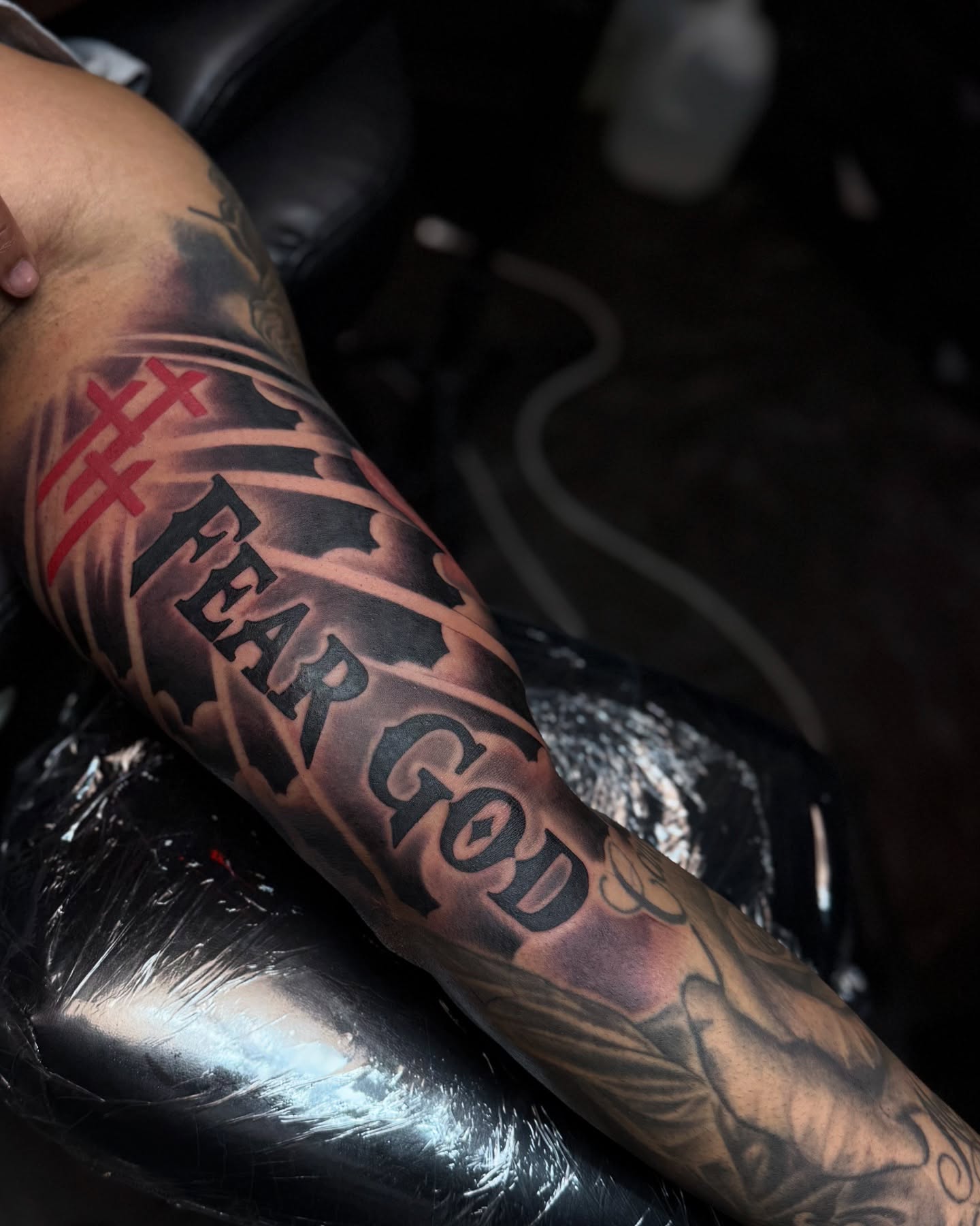 Fear god black and grey tattoo on the forearm by Angels tattoo