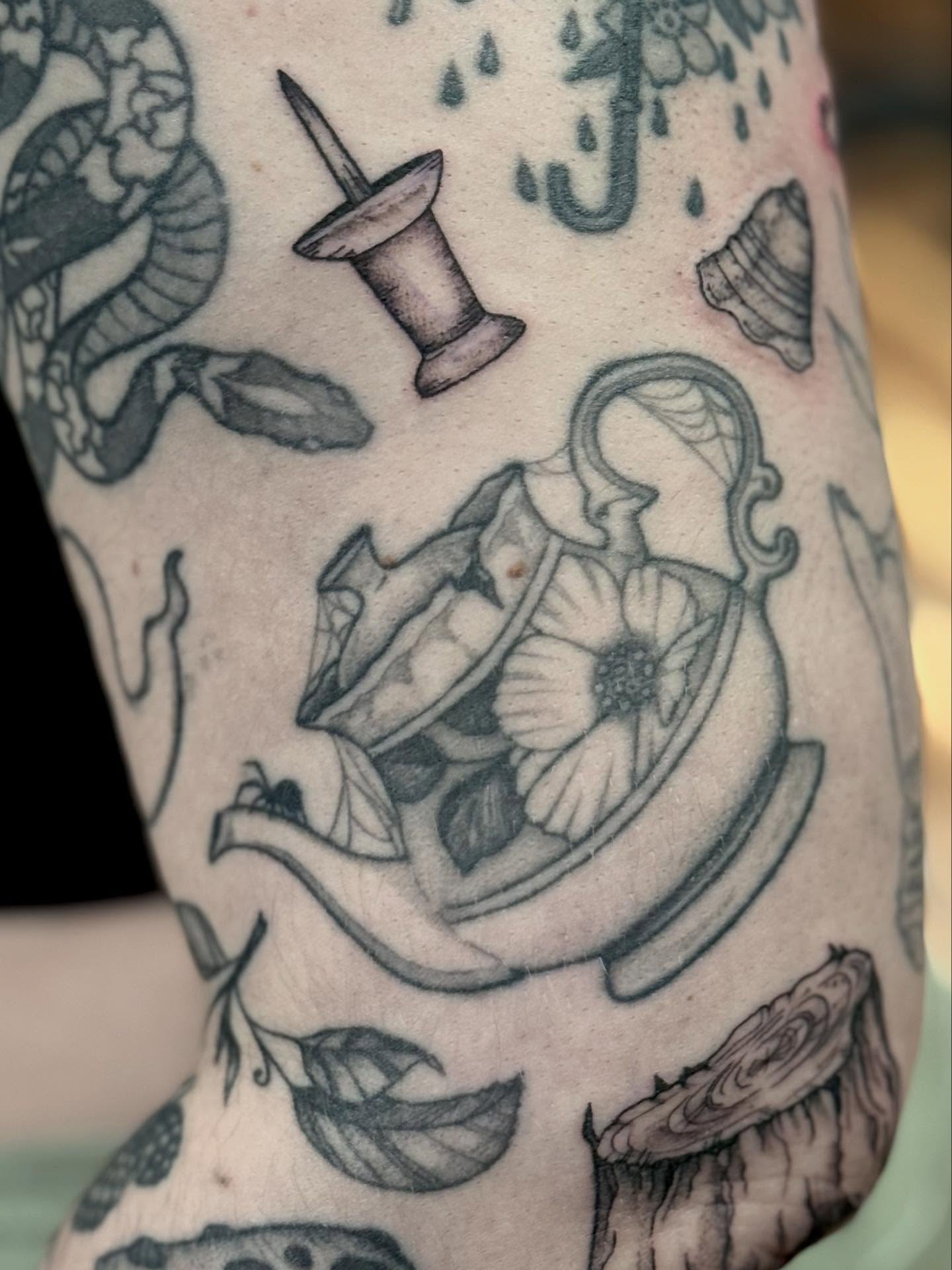 Tea cup and saucer black and grey tattoo on the forearm by Katie Stacy