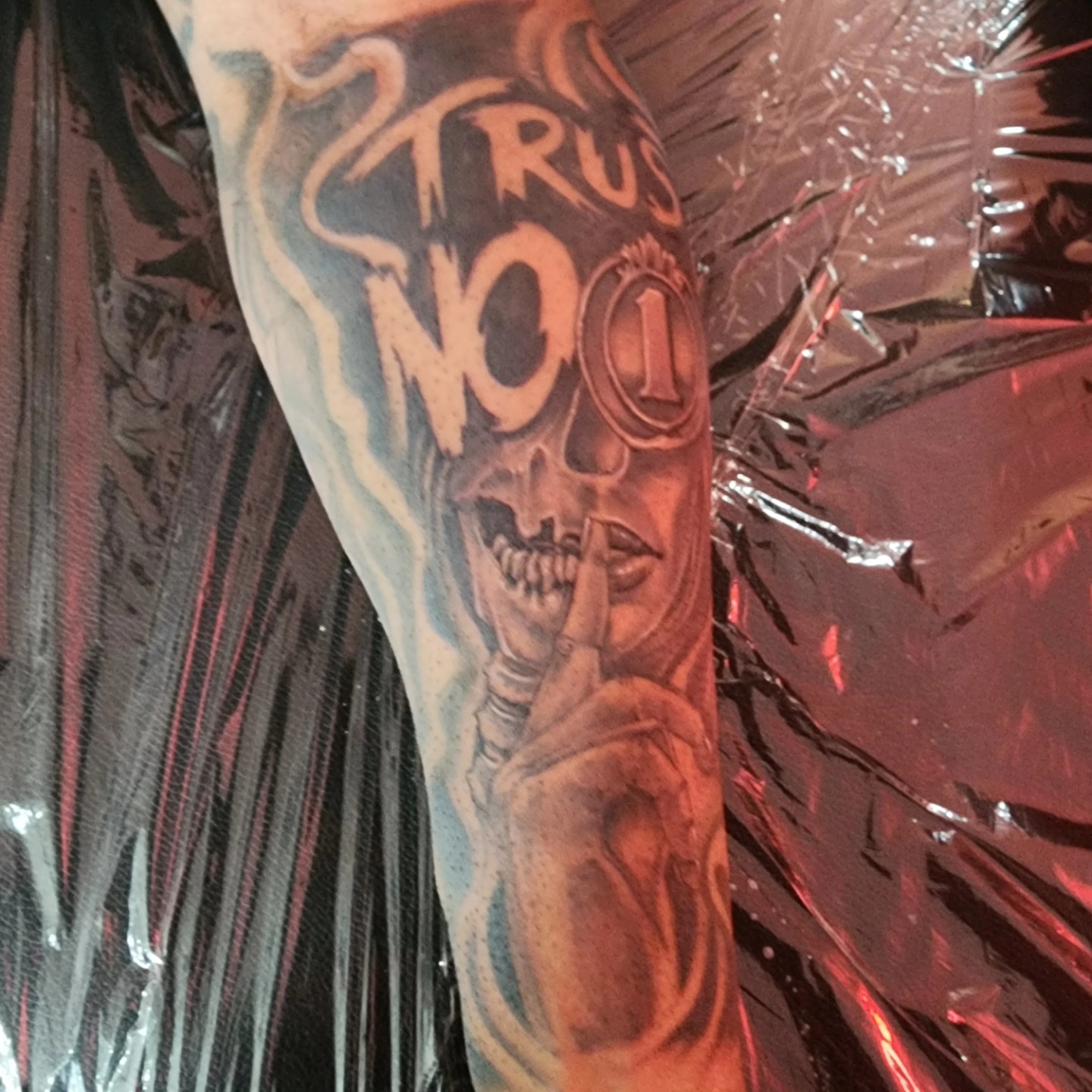 Skull with finger realism tattoo on the forearm by Joe Garcia