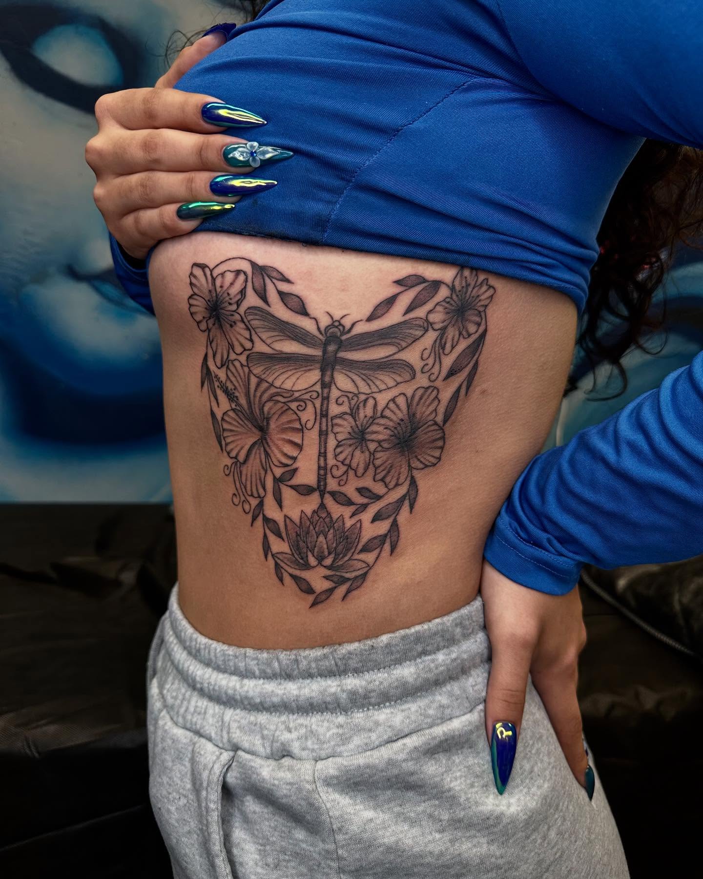 Dragonfly and flowers black and grey tattoo on the ribs by Kimberly landin