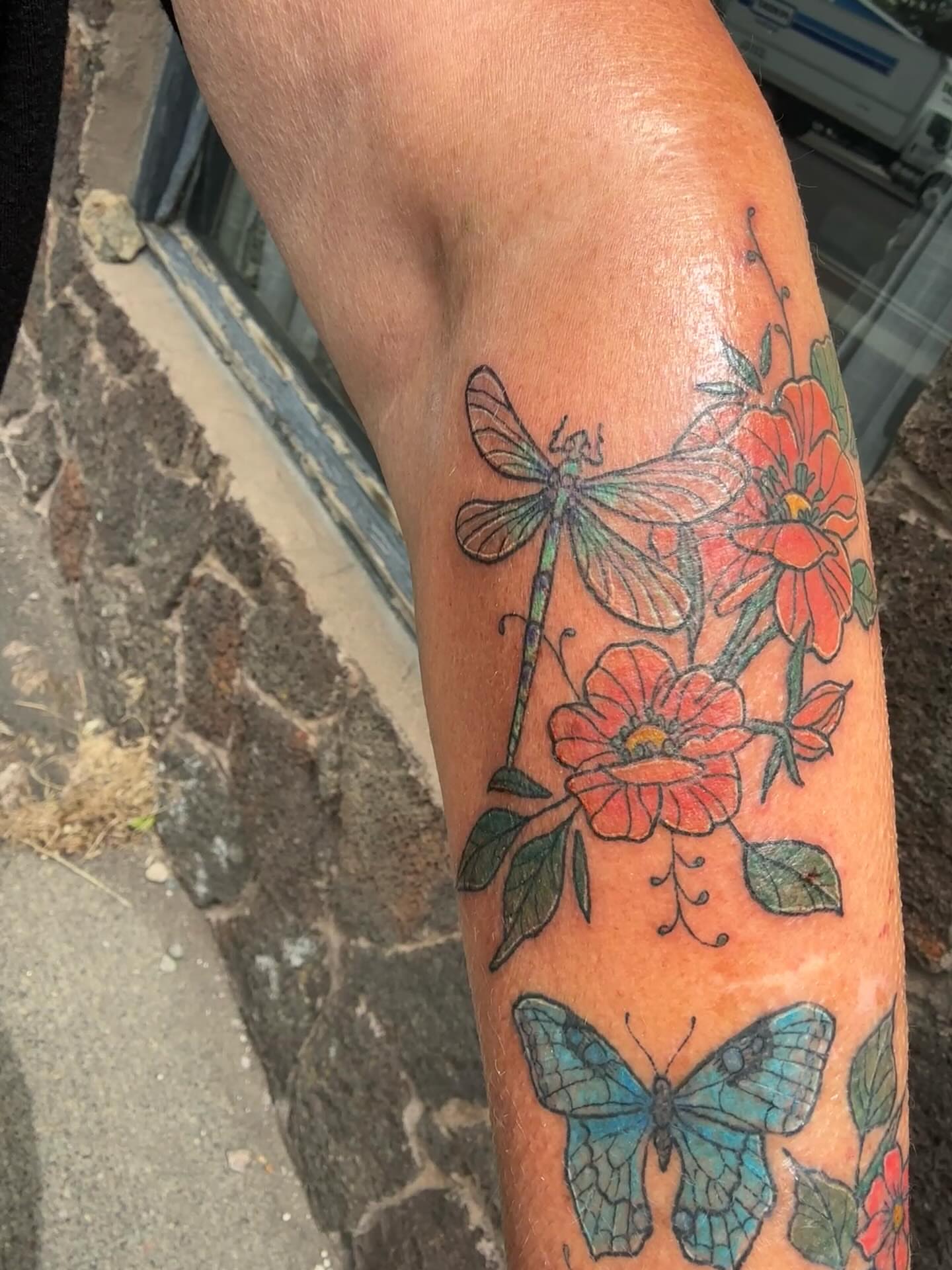 Dragonfly and flowers new school tattoo on the forearm by goose 🪿