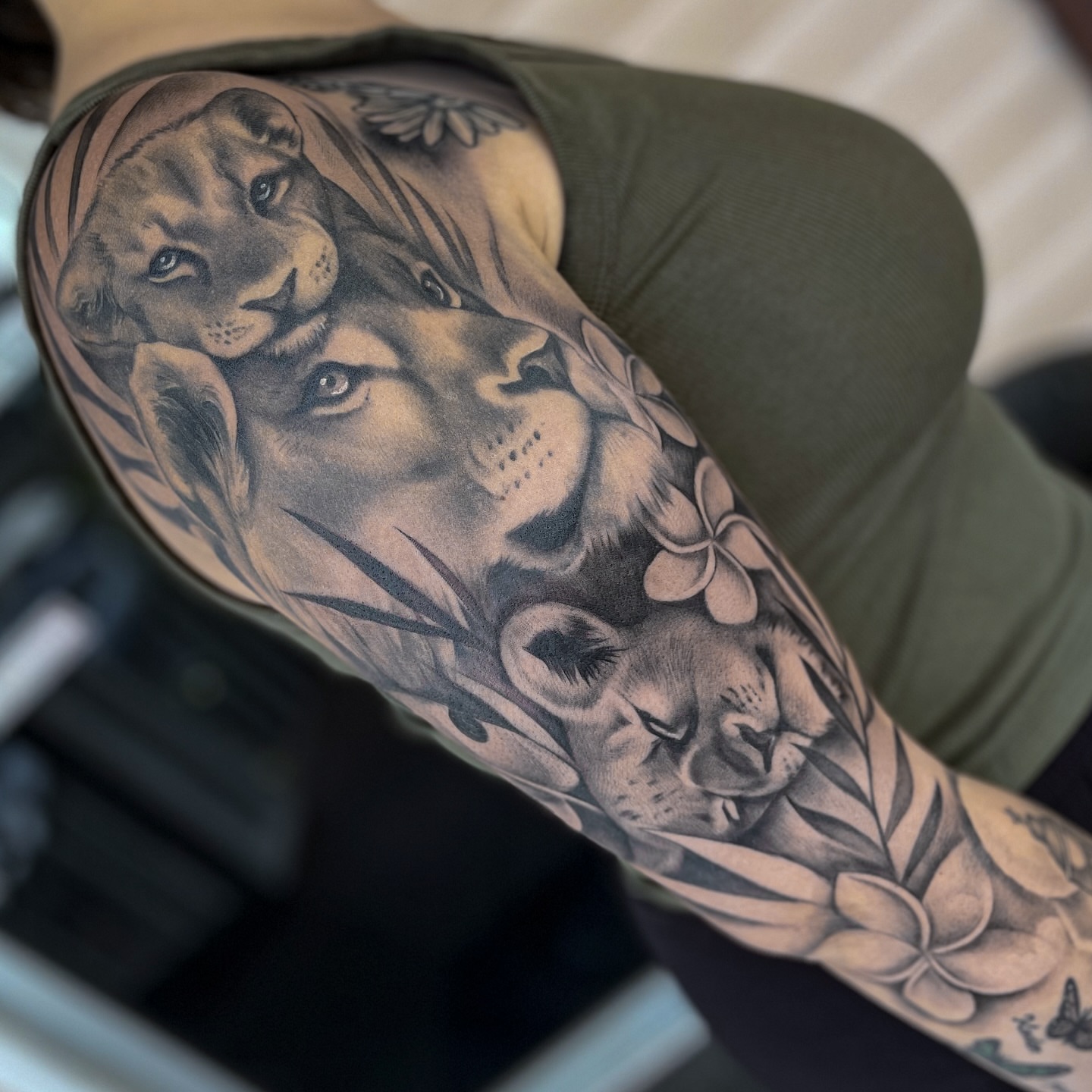 Lion and flowers realism tattoo on the forearm by Erica Olivier