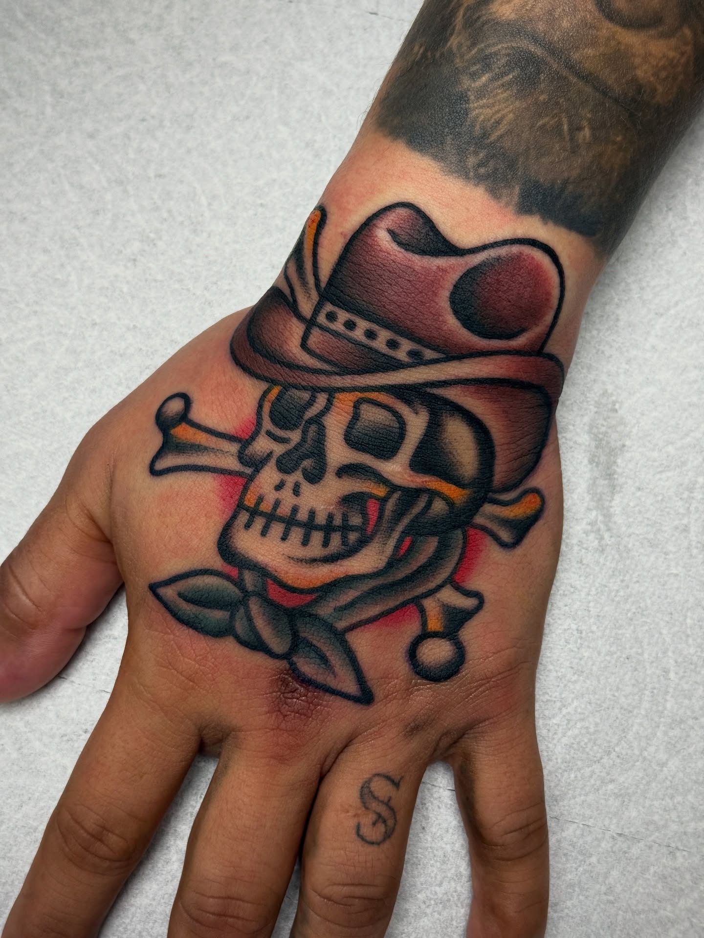 Skull with cowboy hat American traditional tattoo on the hand by Jordan Allen