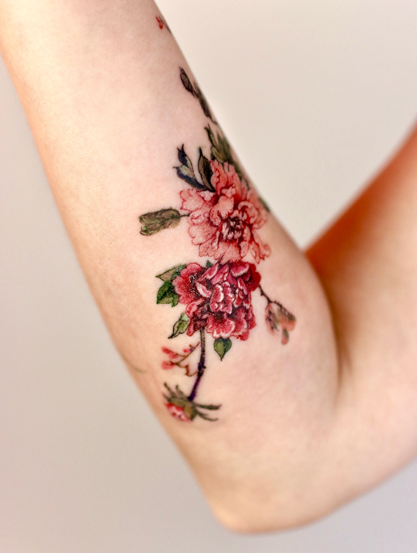 Floral bouquet watercolor tattoo on the forearm by Isle