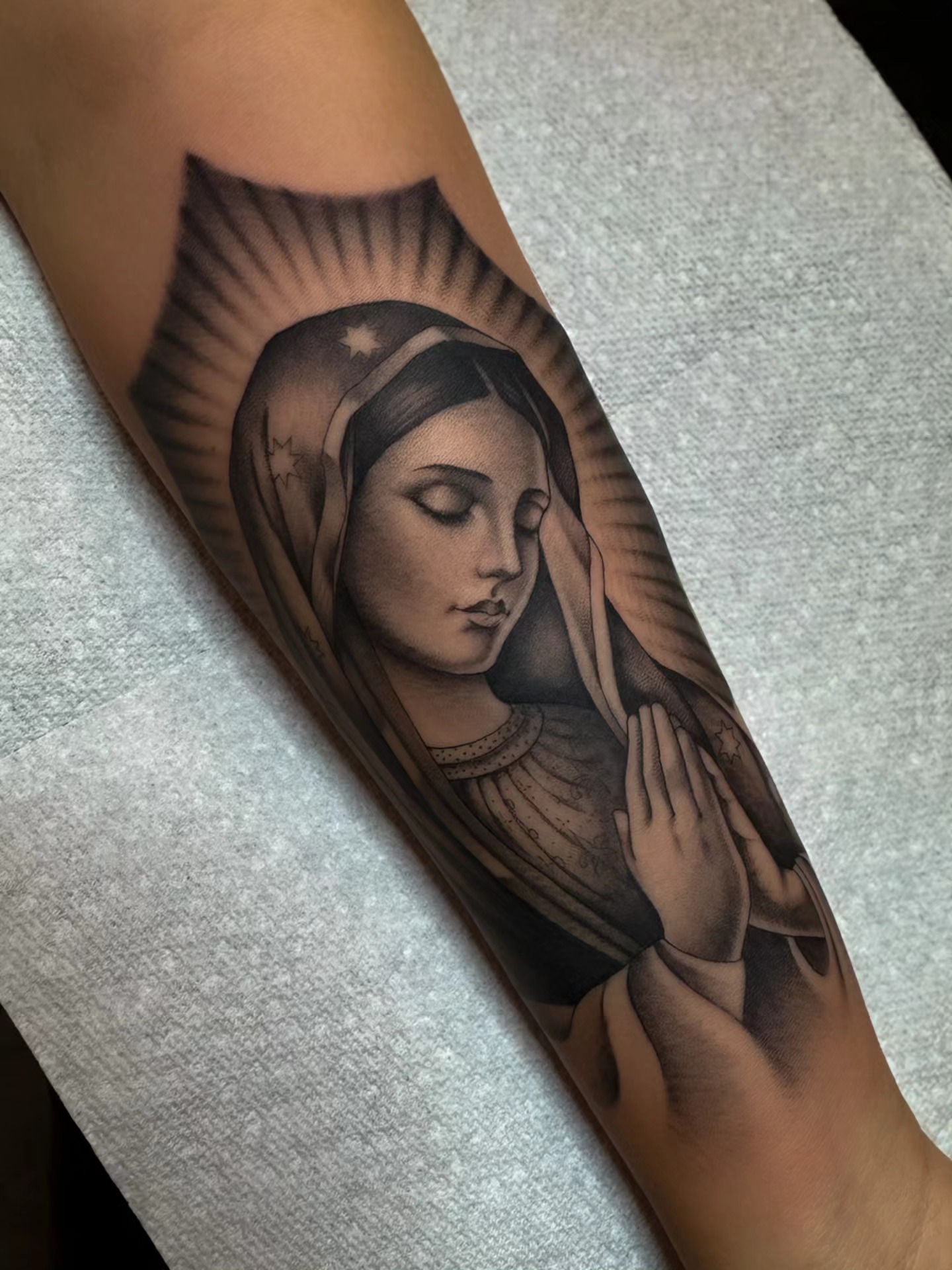 Religious figure praying realism tattoo on the forearm by Kelsi Steffensen