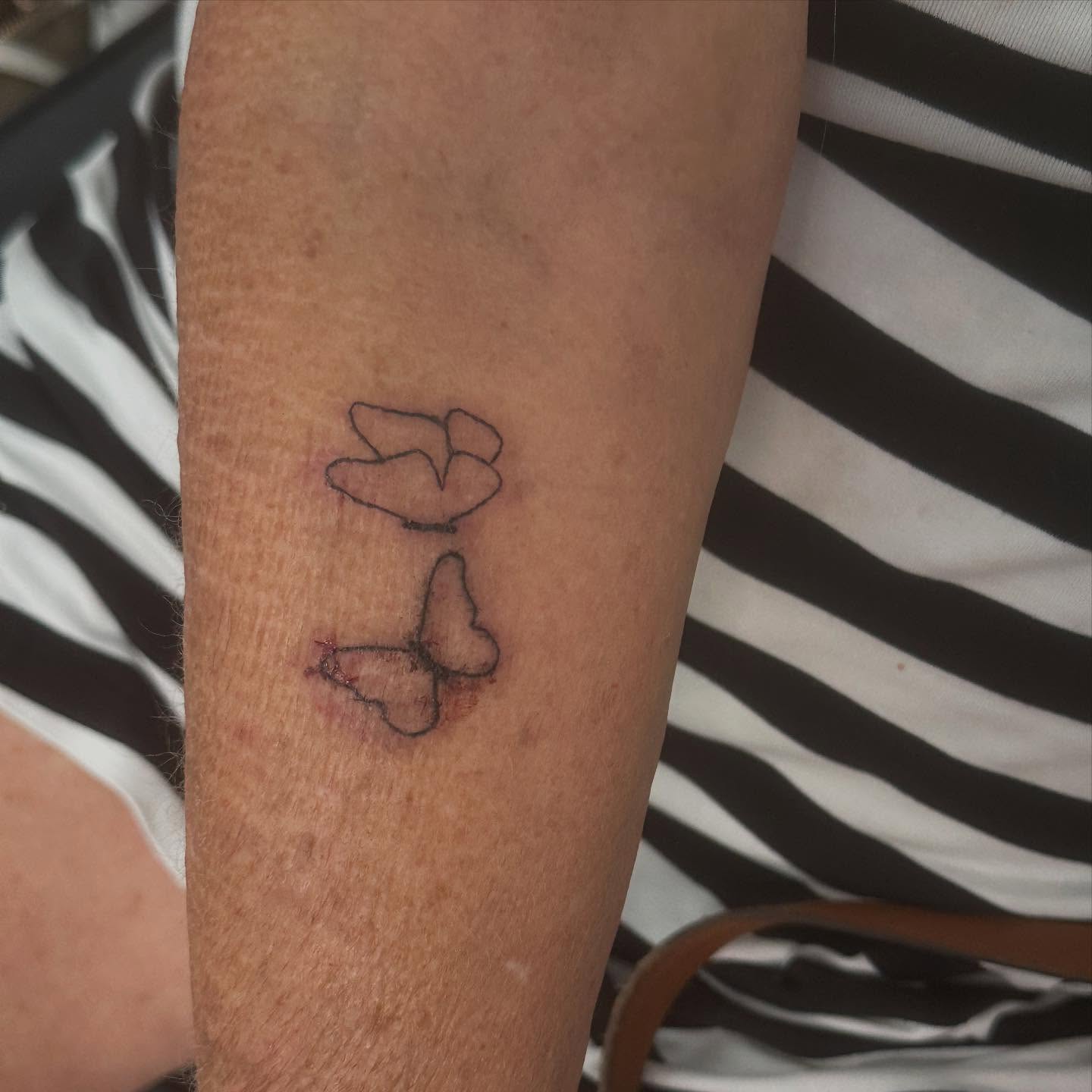 Rose and butterfly black and grey tattoo on the forearm by Victoria Cooper