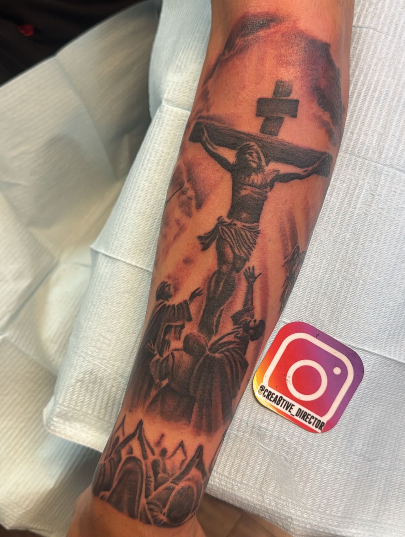 Religious crucifixion scene realism tattoo on the forearm by Cedric Fleming