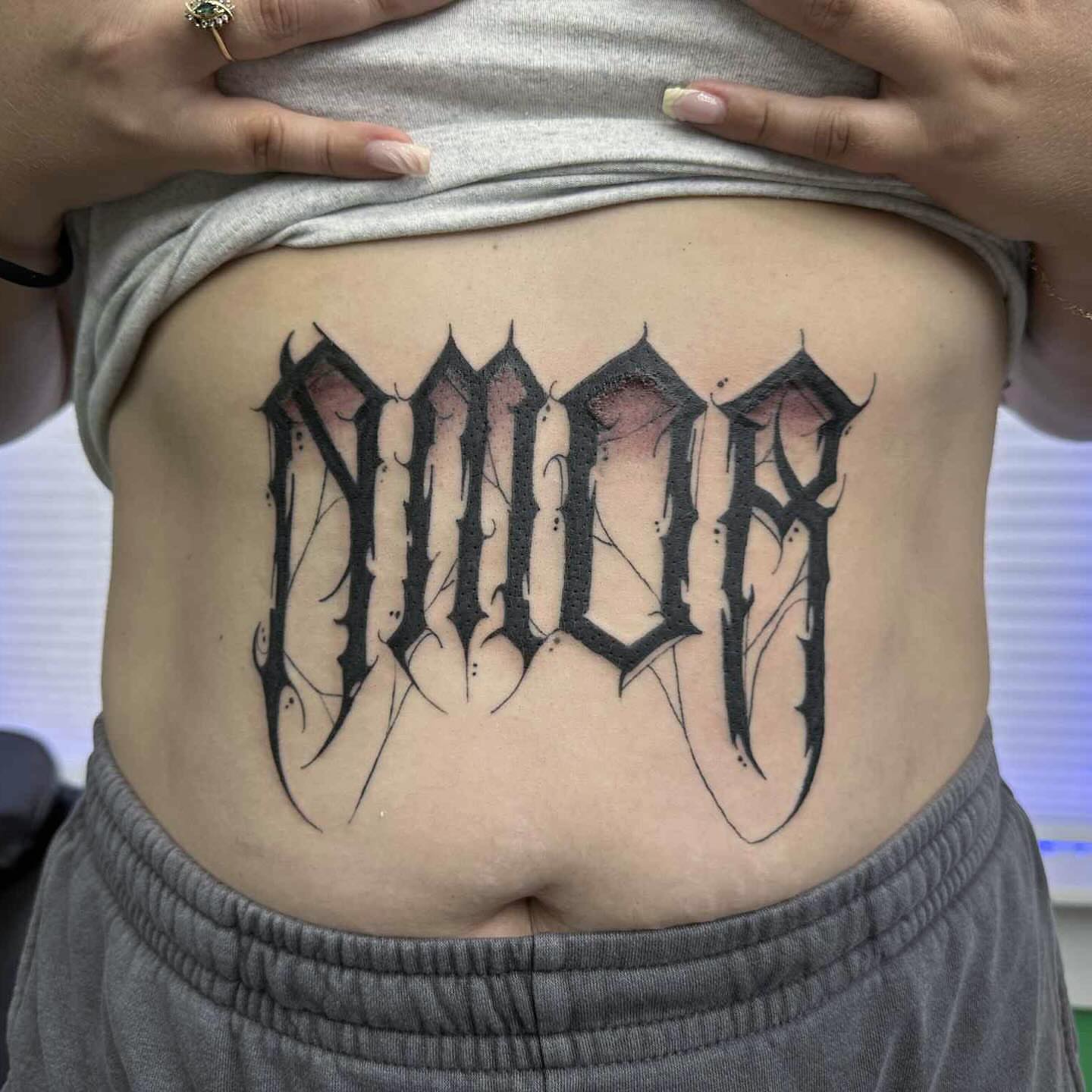 Gothic lettering tattoo on the ribs by Haley Winfree