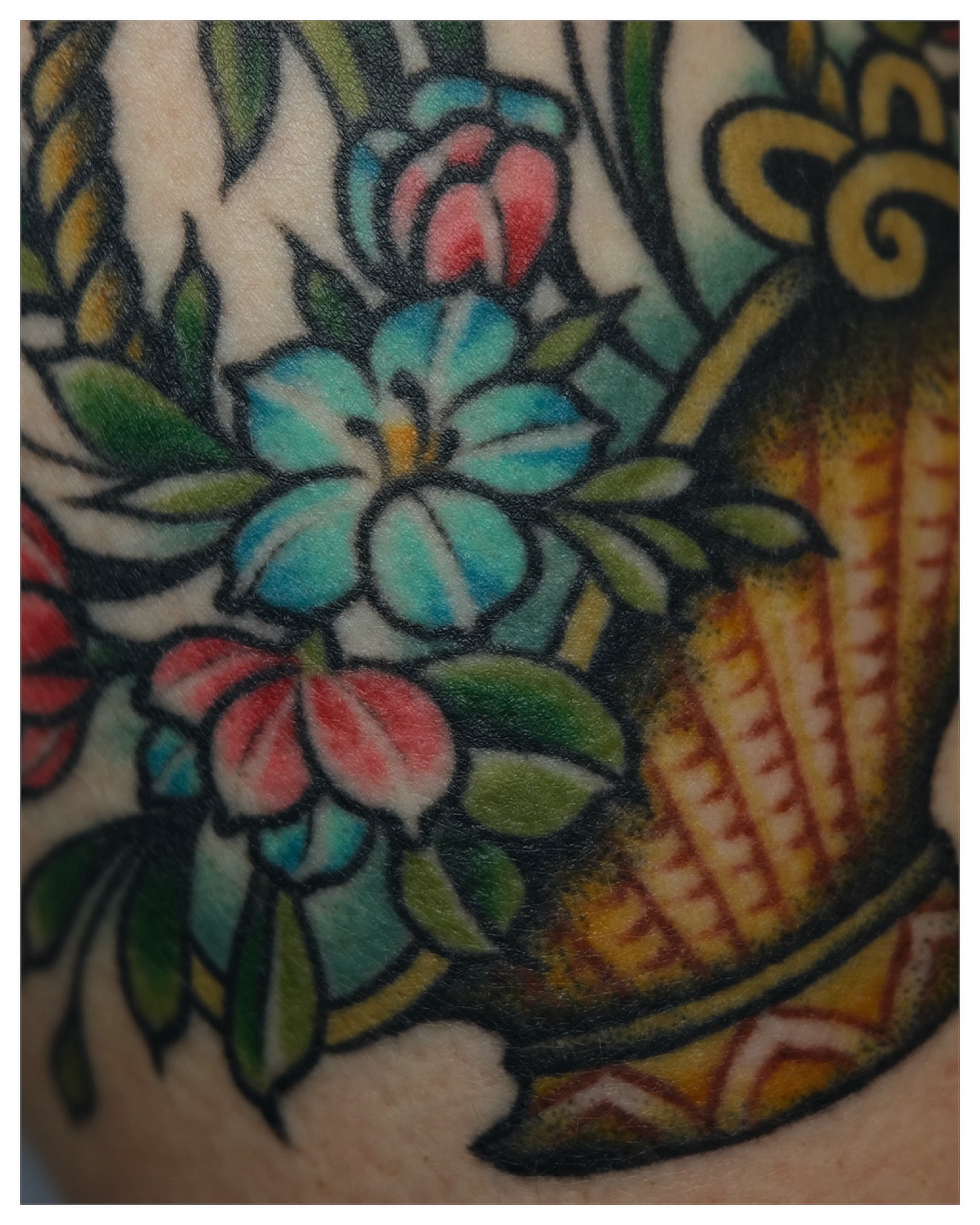 Floral arrangement American traditional tattoo on the upper arm by Tony Talbert, Fredericksburg, Virginia