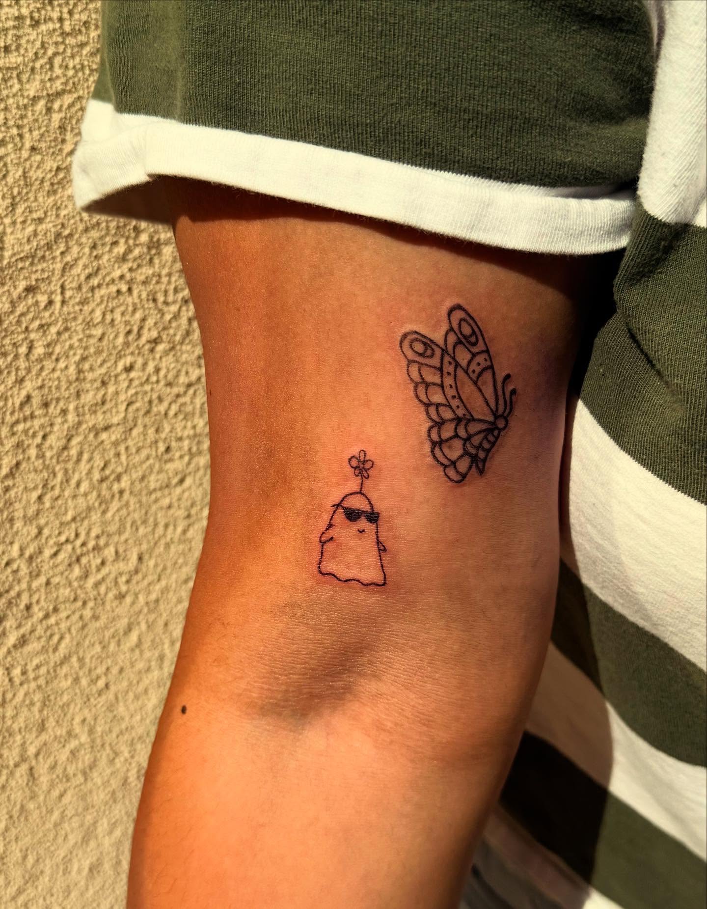 Butterfly and character minimalist tattoo on the forearm by Kylee Snow