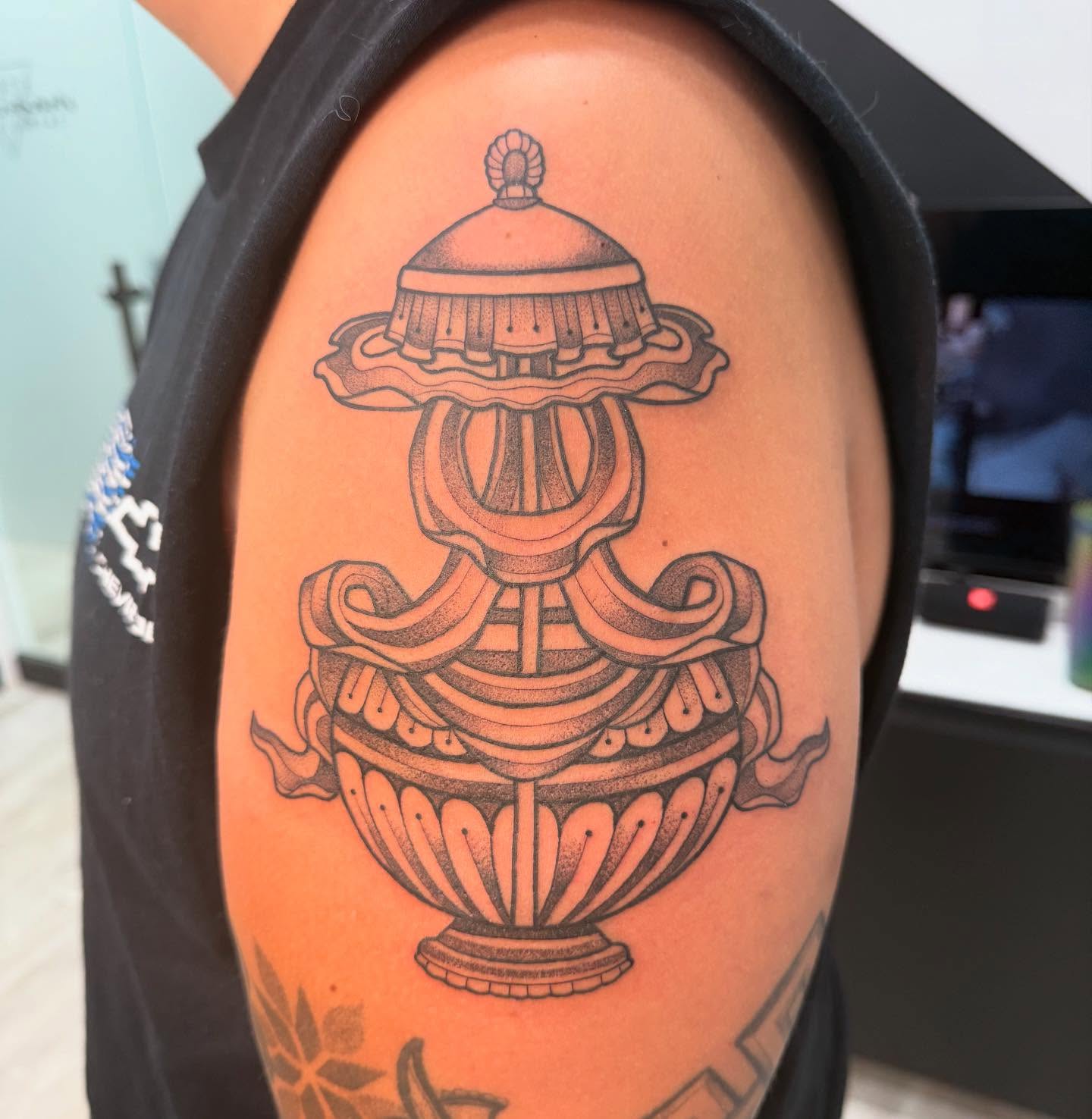 Urn black and grey tattoo on the shoulder by Shelby Raia
