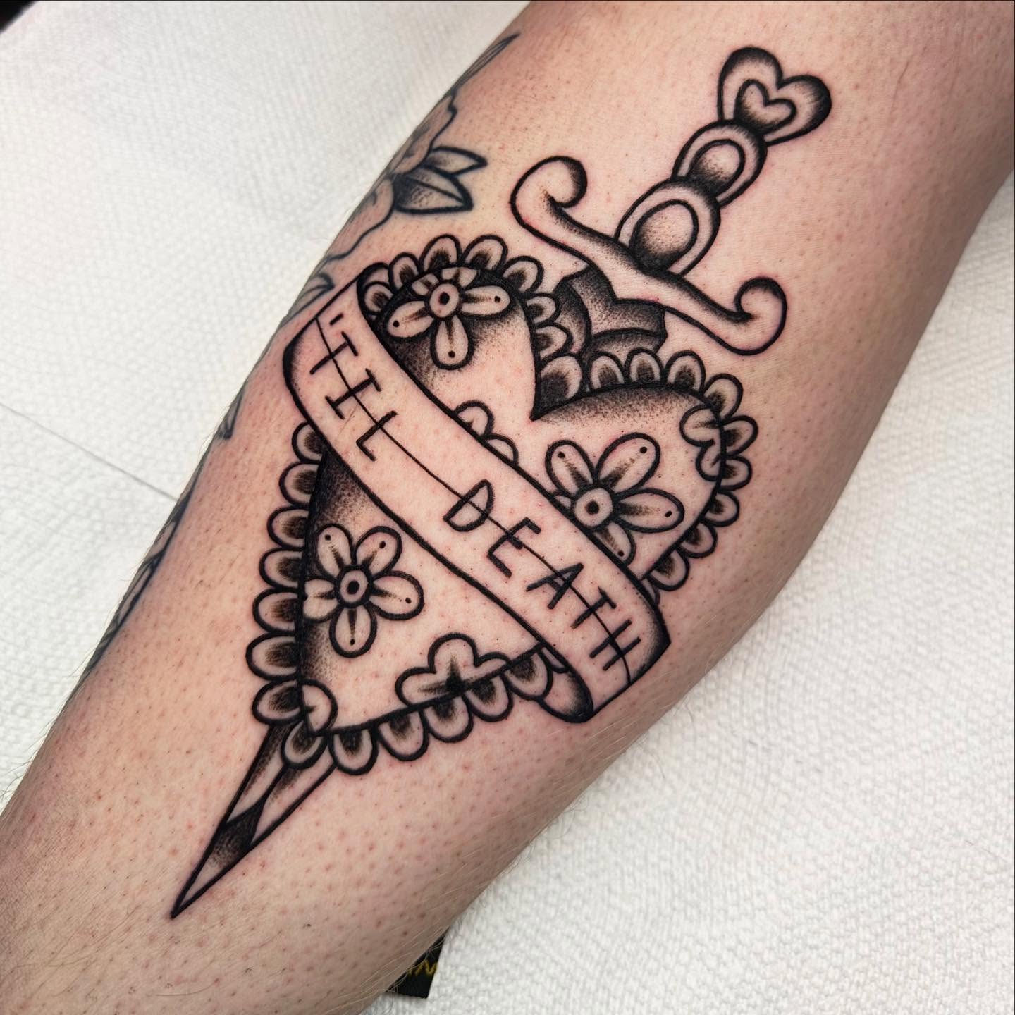 Heart with dagger American traditional tattoo on the forearm by Shana