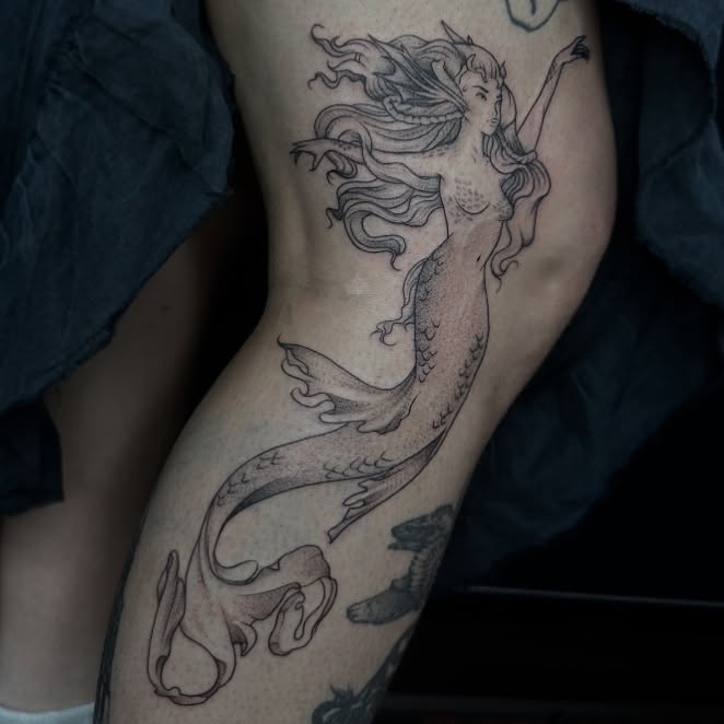 Mermaid black and grey tattoo on the thigh by Rachel Martinez