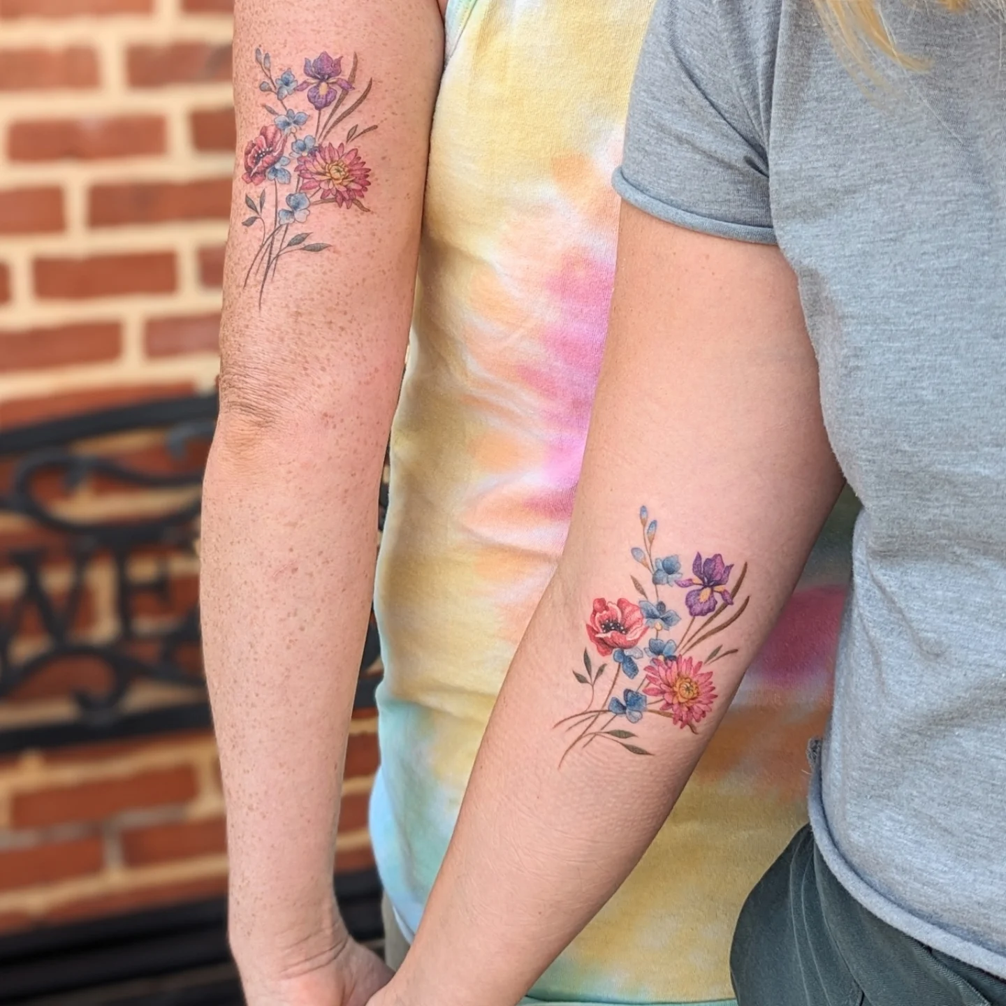 Floral bouquet watercolor tattoo on the forearm by Maddie