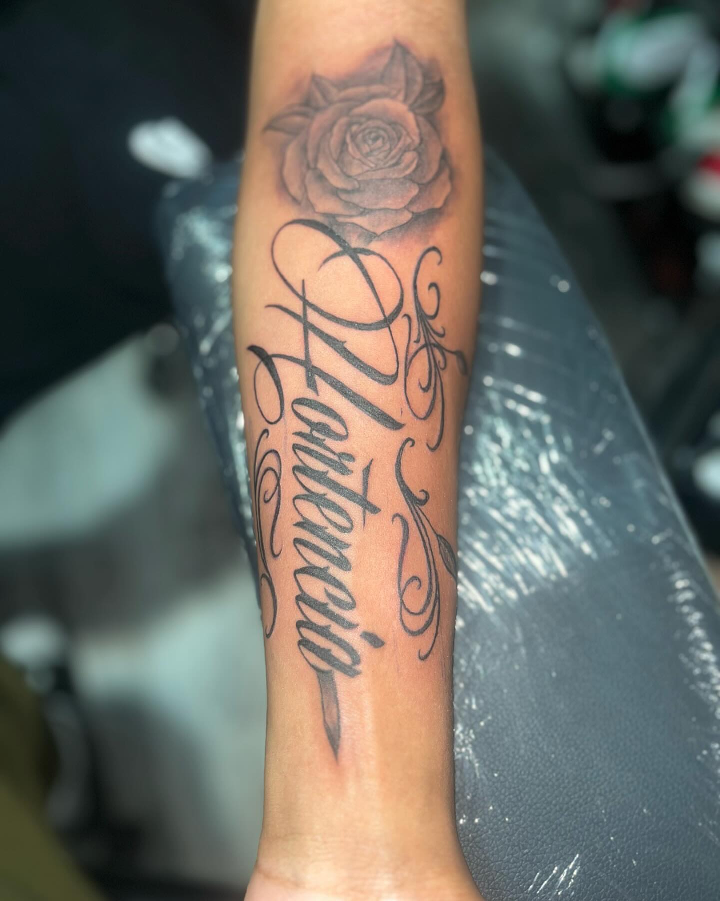 Rose and script ornamental tattoo on the forearm by Bris