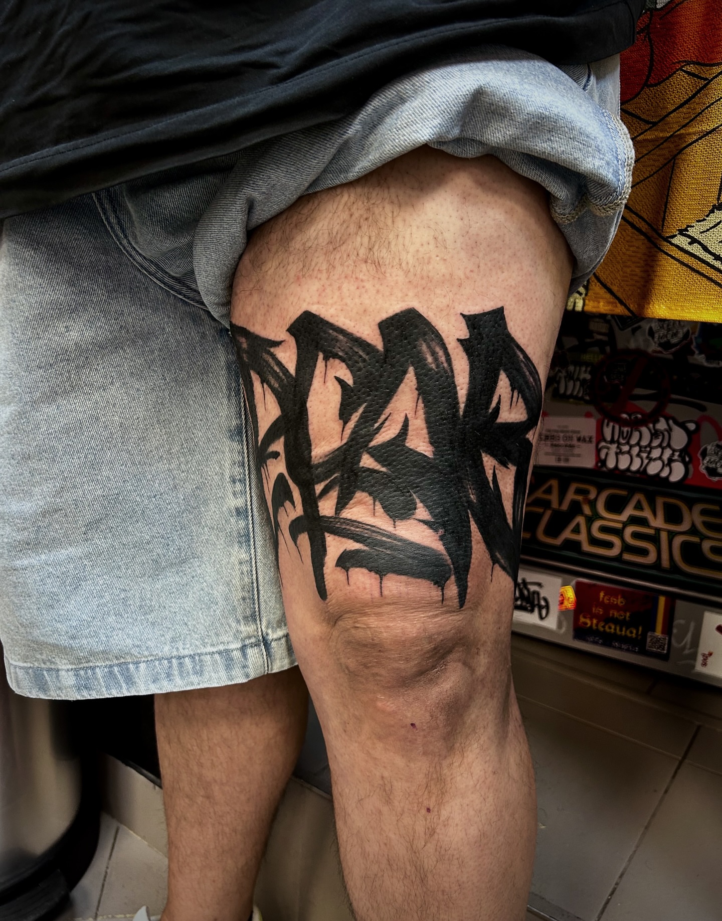 Graffiti-style lettering black and grey tattoo on the thigh by Comastein__________✍🏼️