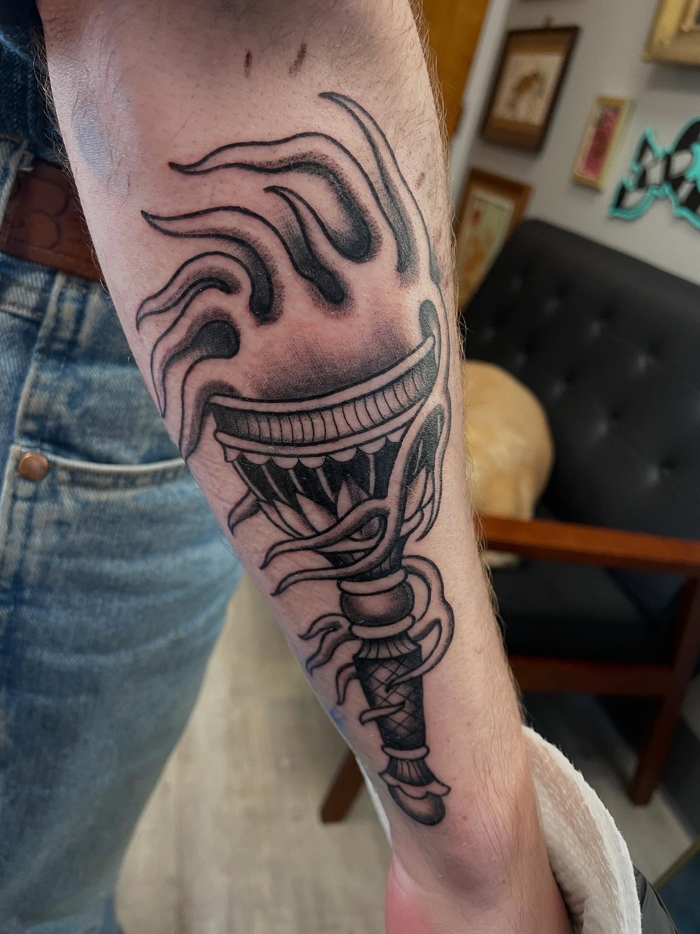 Mask black and grey tattoo on the forearm by Josh Johns