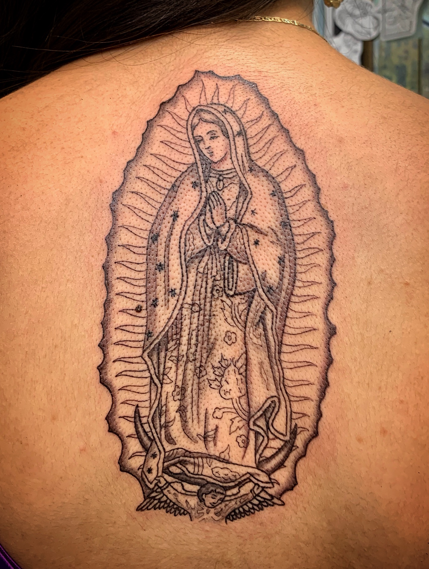 Our Lady of Guadalupe black and grey tattoo on the back by Laura