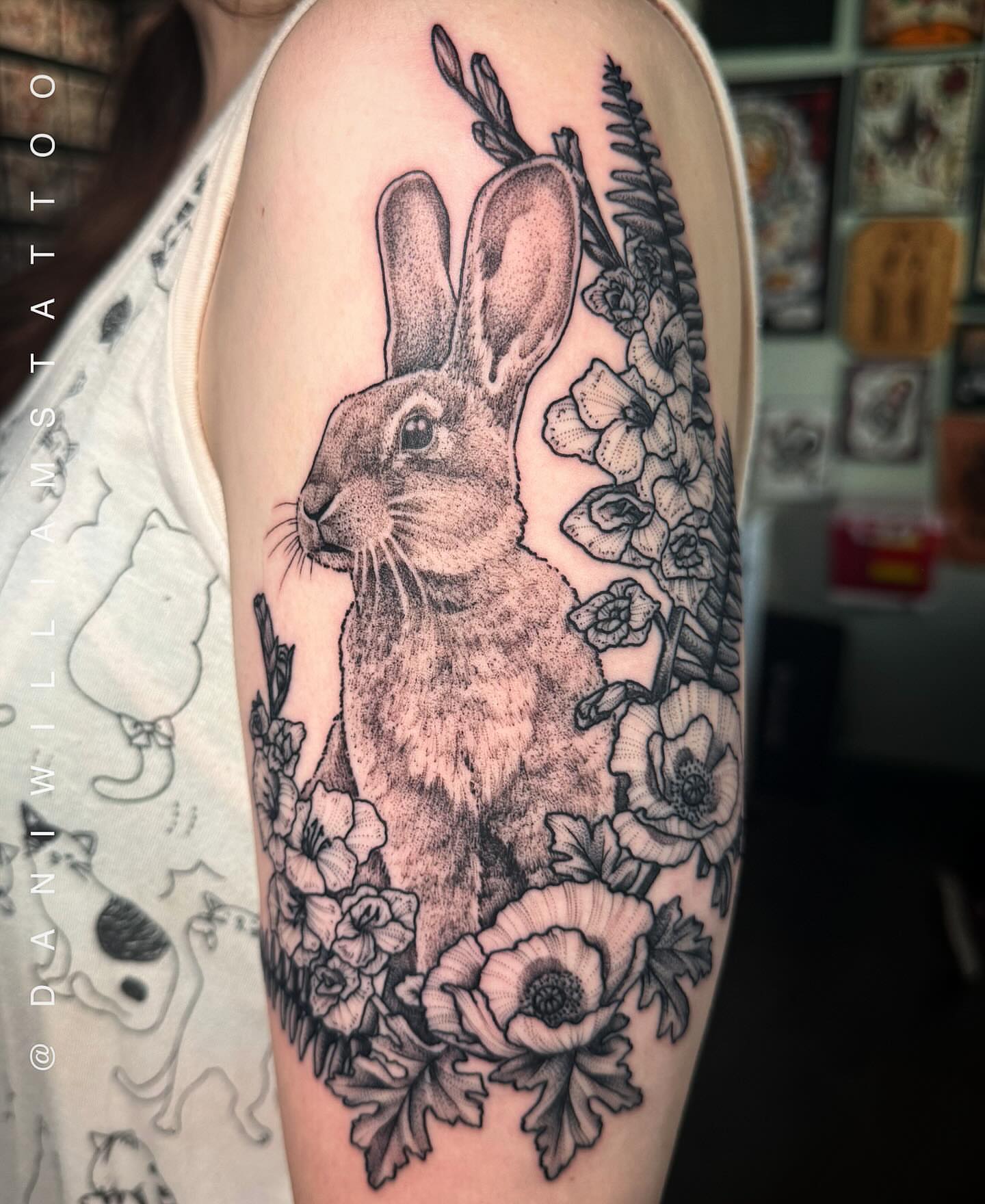Rabbit and flowers realism tattoo on the forearm by Dani Johnson