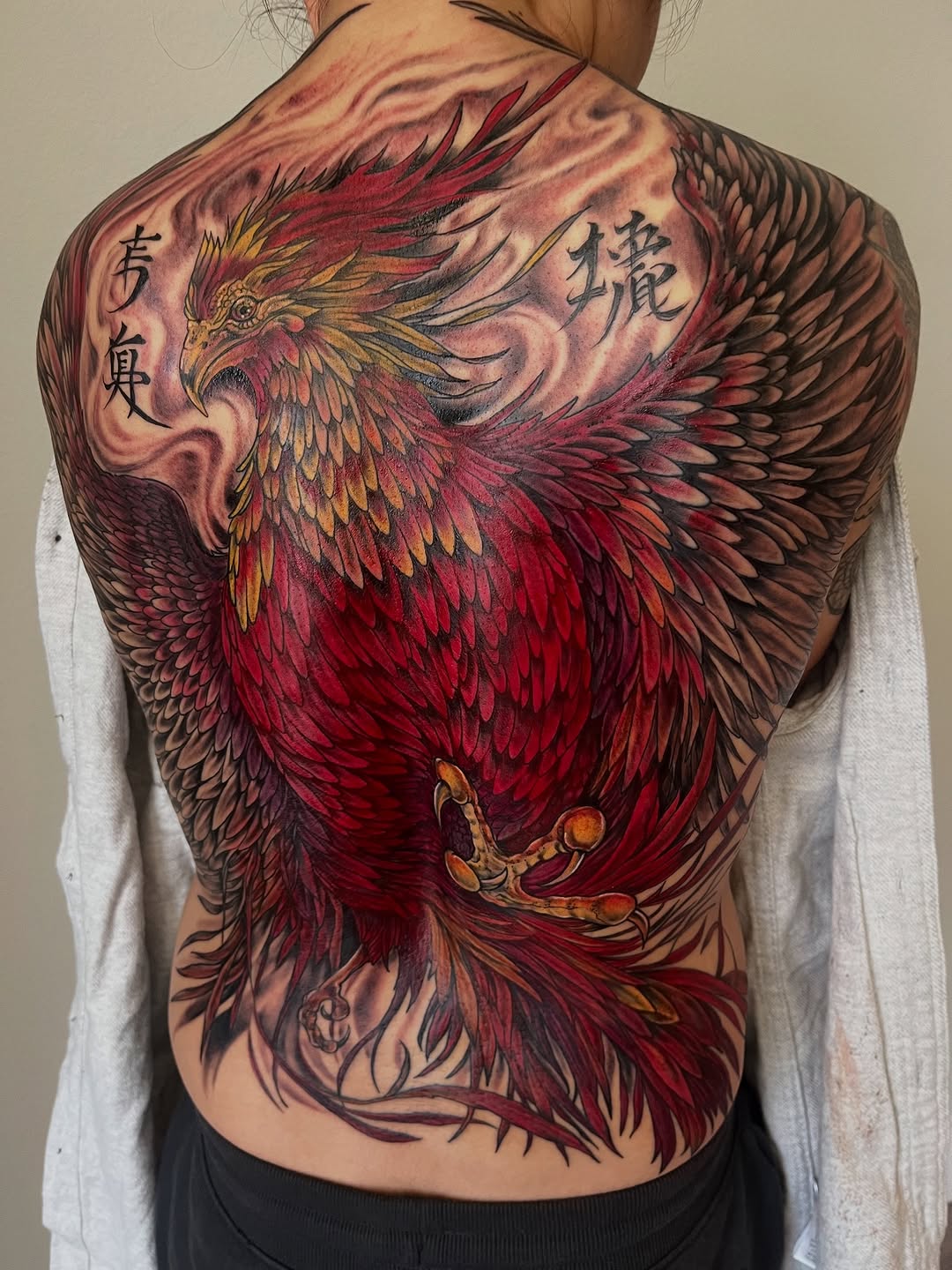 Phoenix with kanji realism tattoo on the back by Janelle Cuba