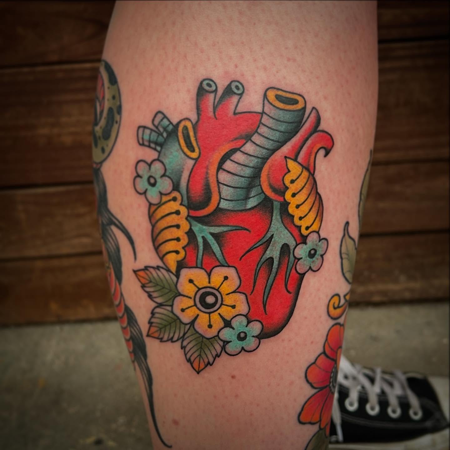Heart with floral elements American traditional tattoo on the leg by Kayla Shoffner